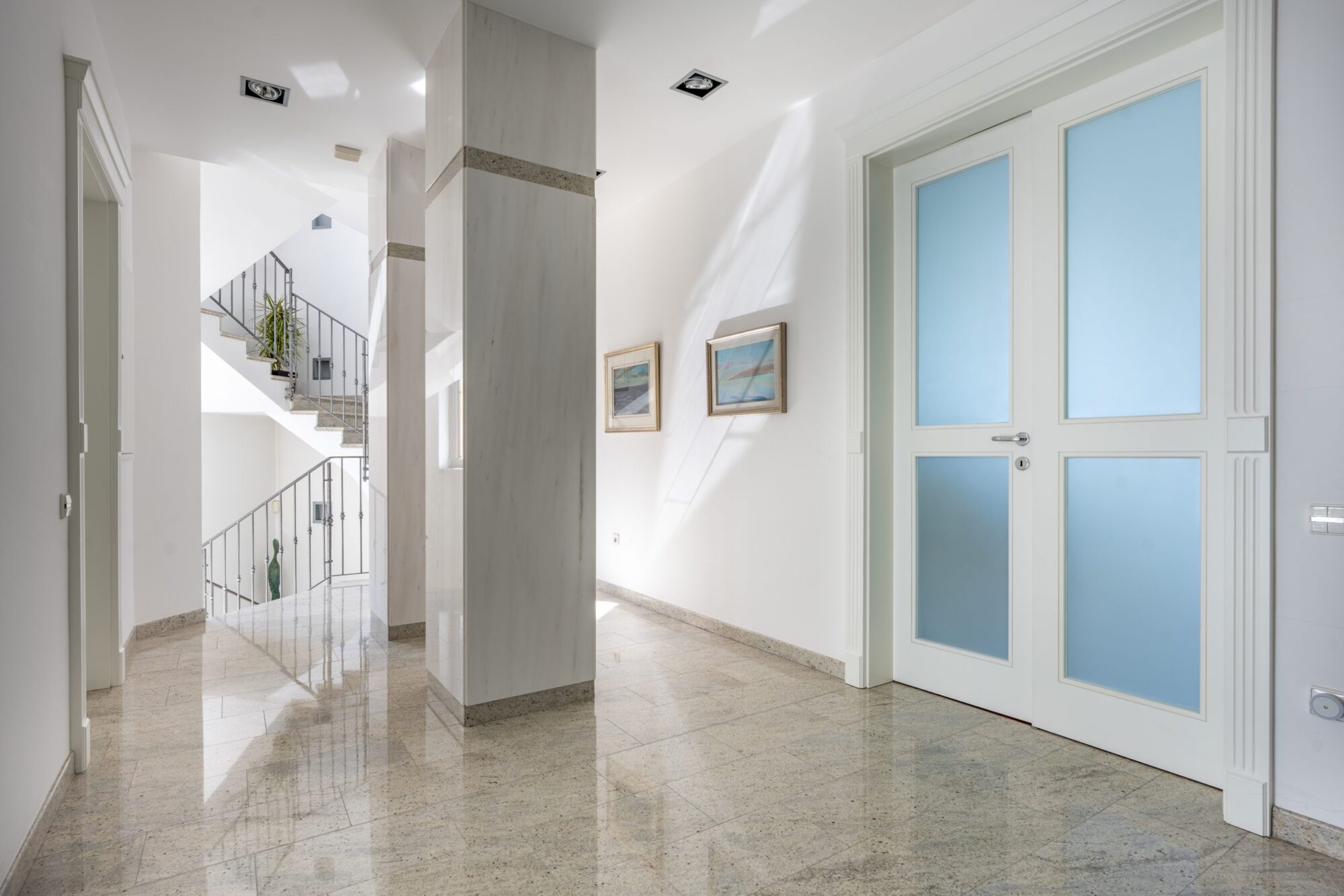 Marble corridor with glass doors and art