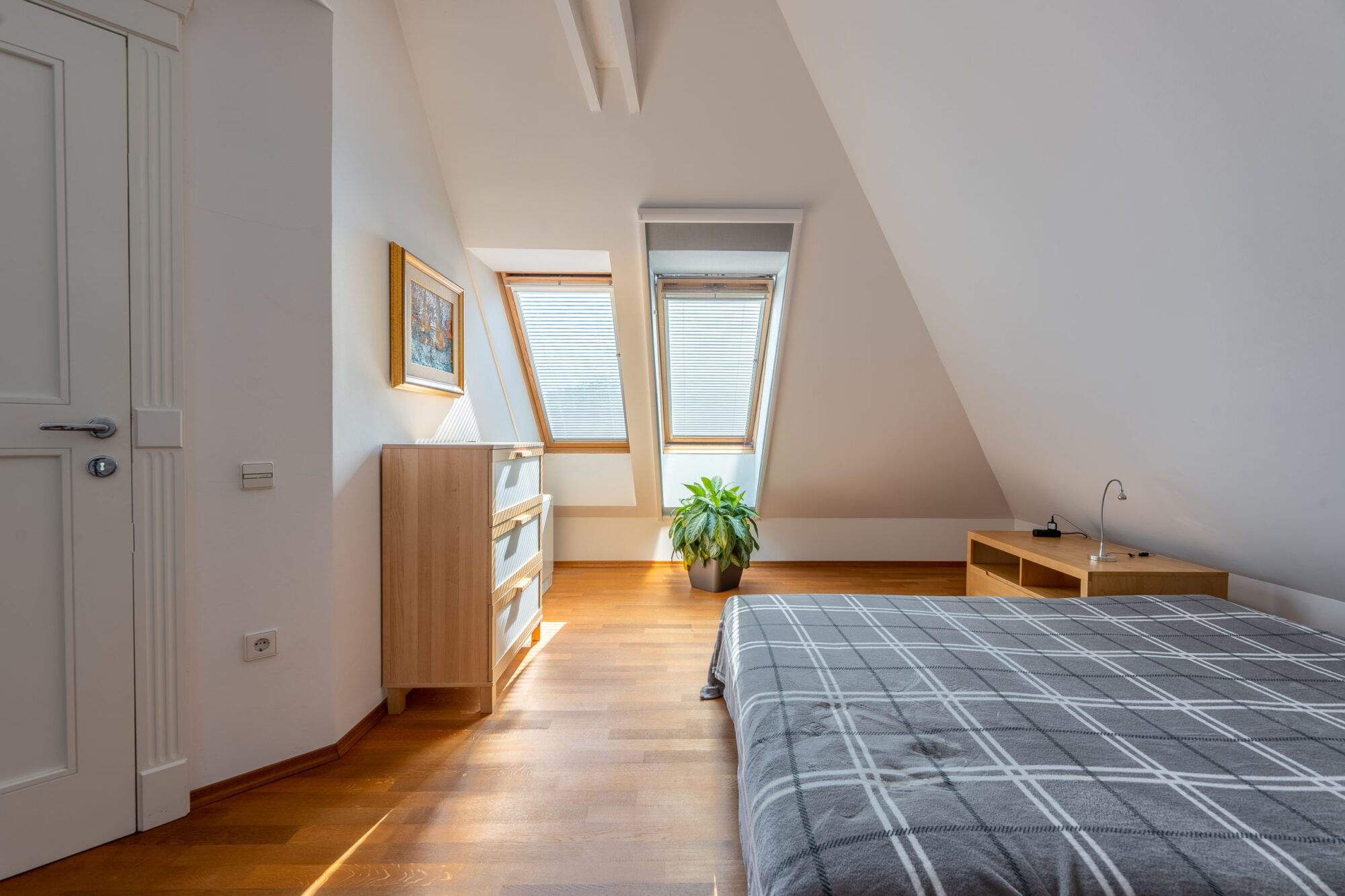 Attic bedroom with skylight and wooden floor