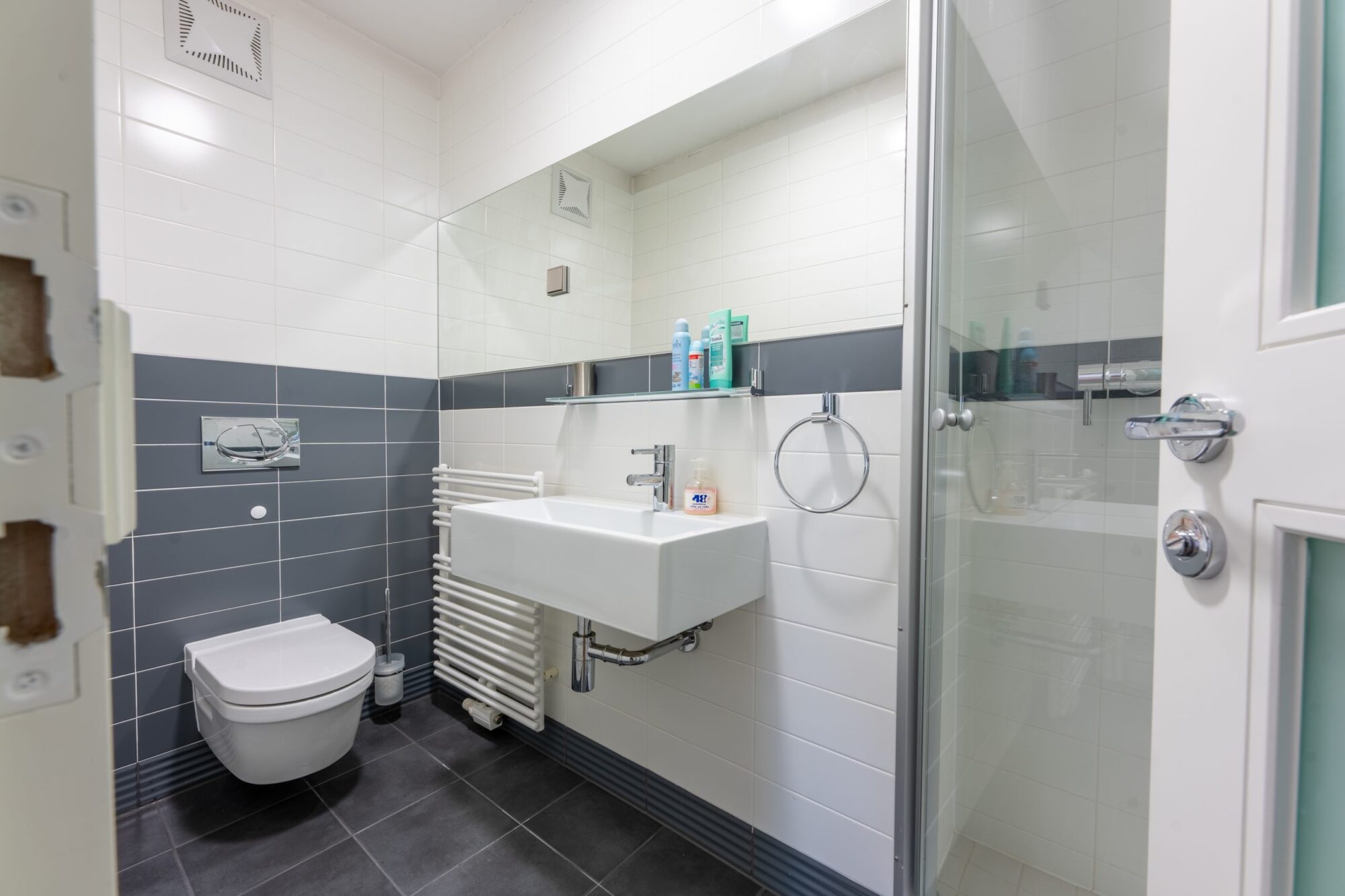 Grey tiled bathroom with sink and shower