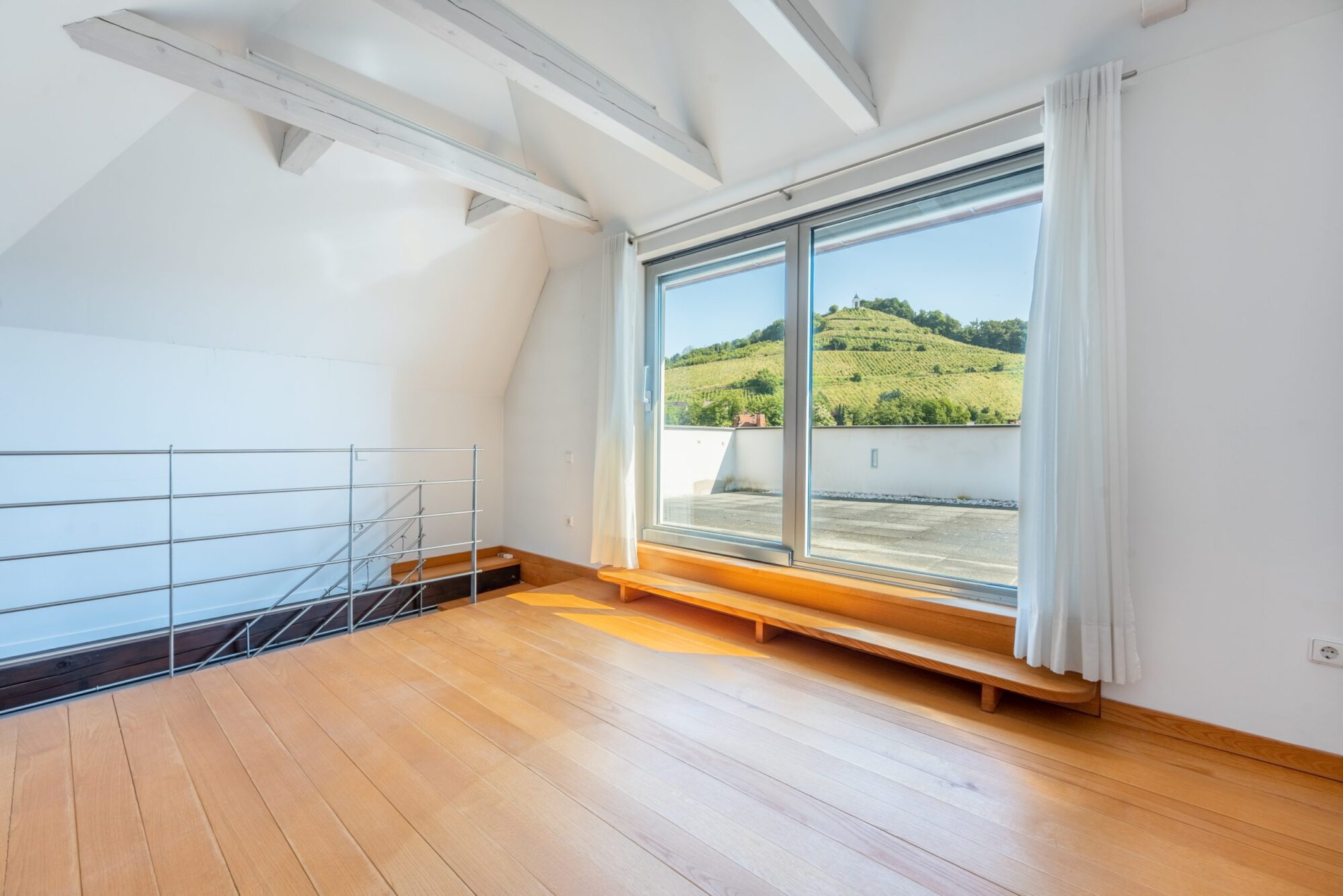 Bright loft room with large window and view