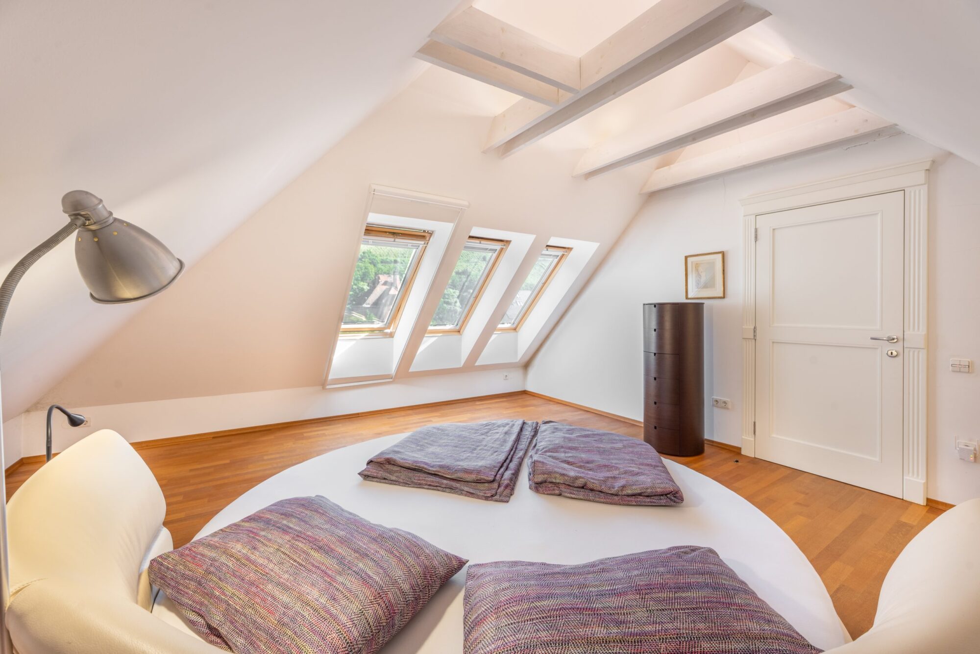Attic bedroom with beams and pillow arrangement