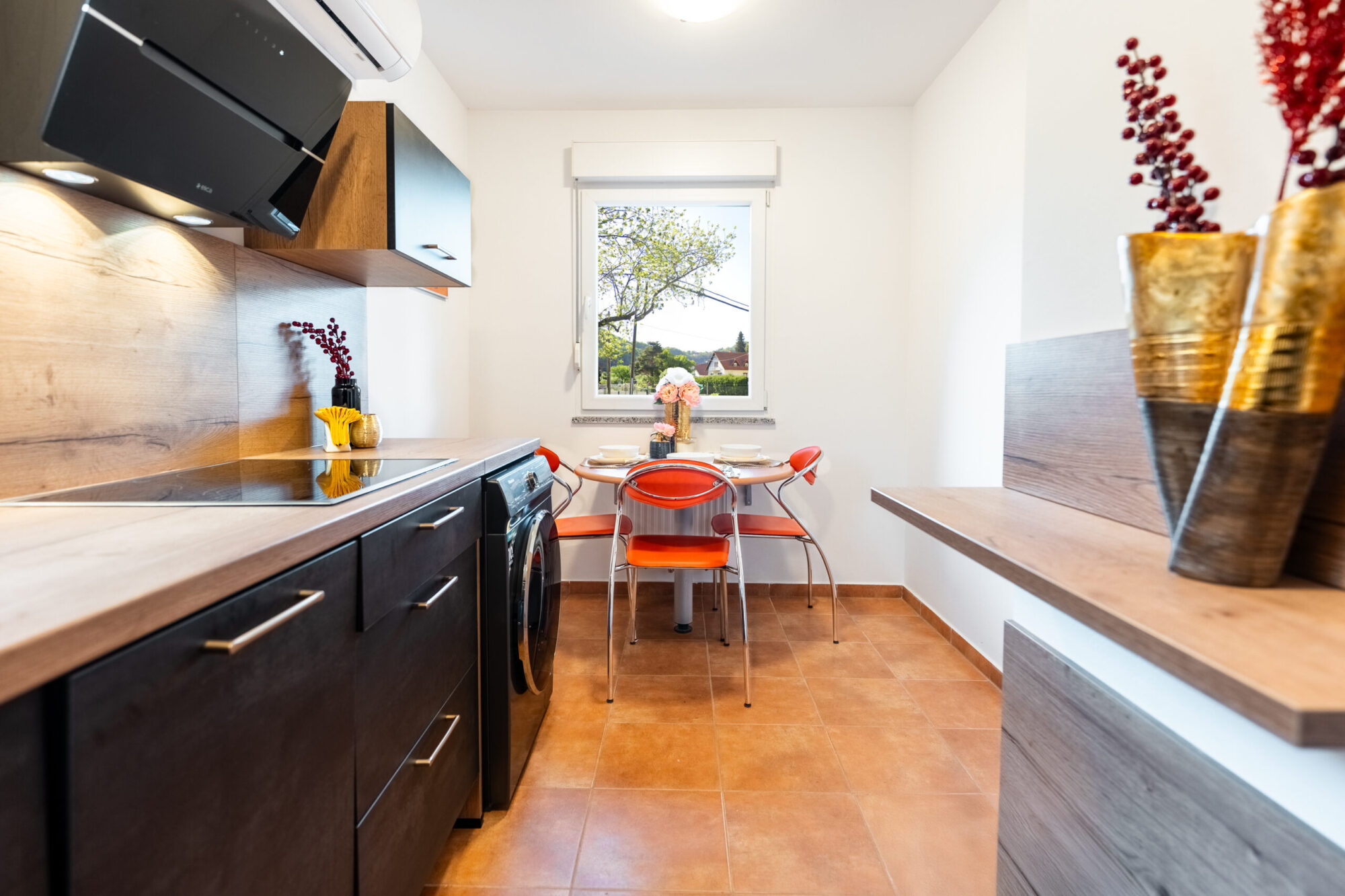 Kitchen with dining table and orange chairs by window