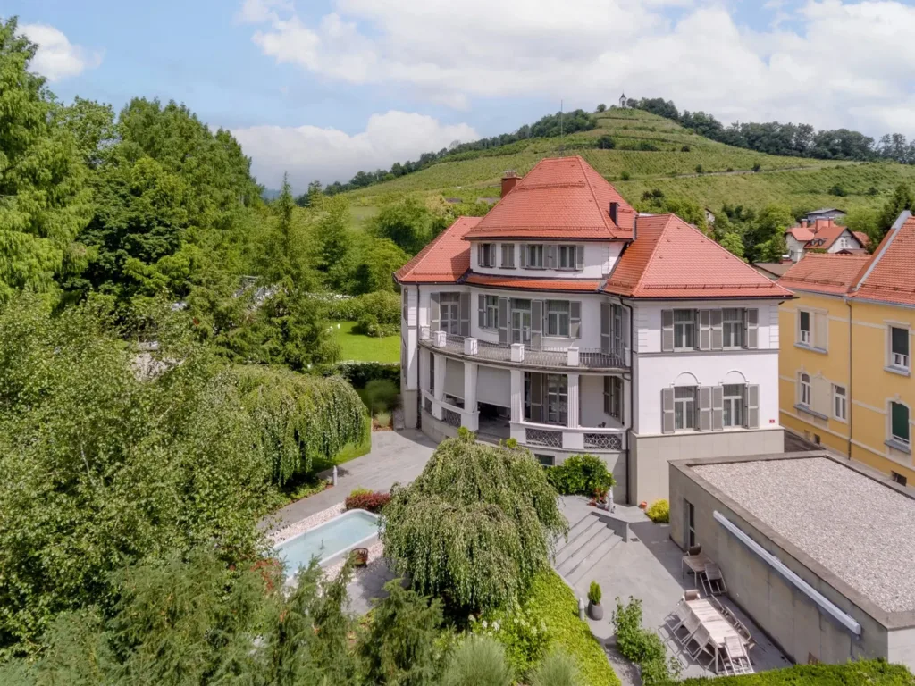 Aerial view of historic villa with pool and garden