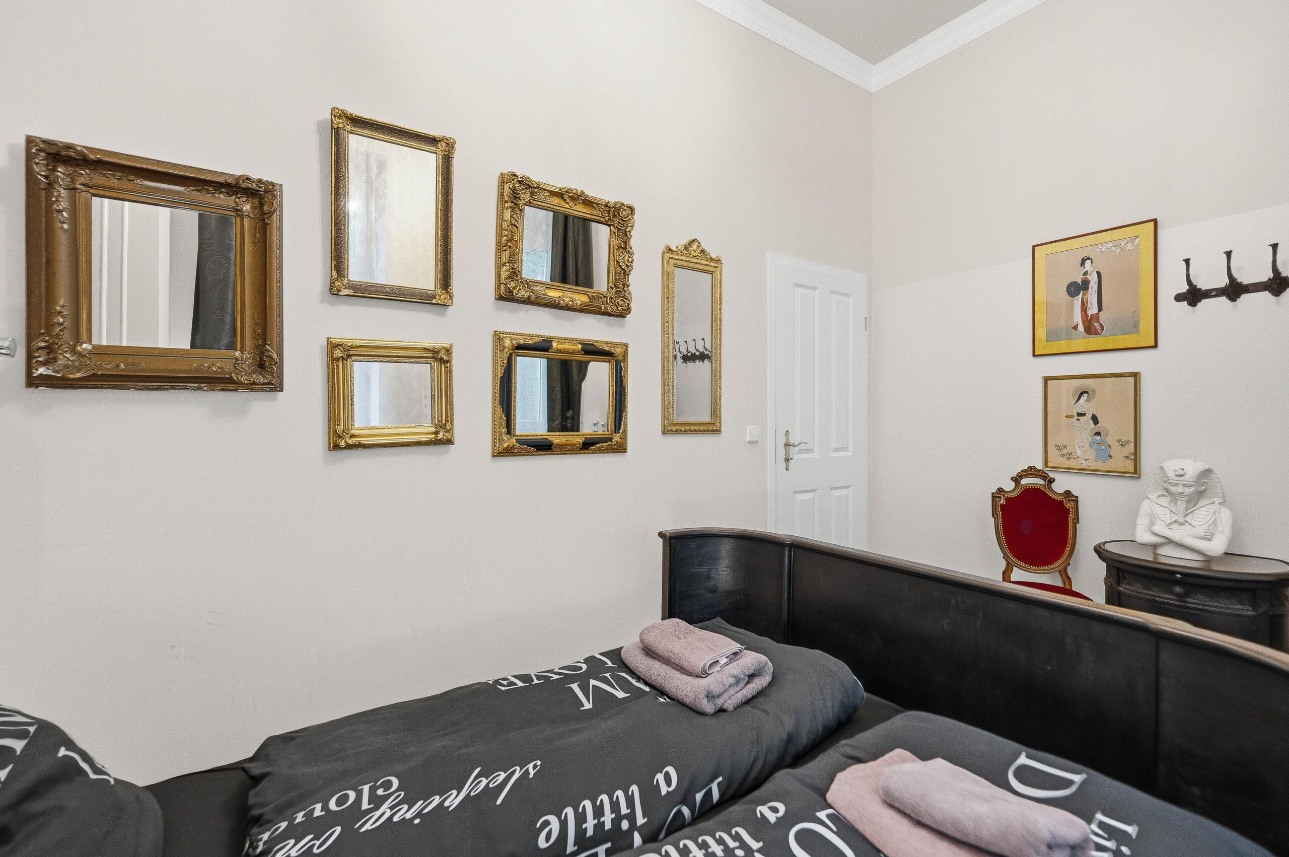 Bed with gallery of vintage mirrors on wall