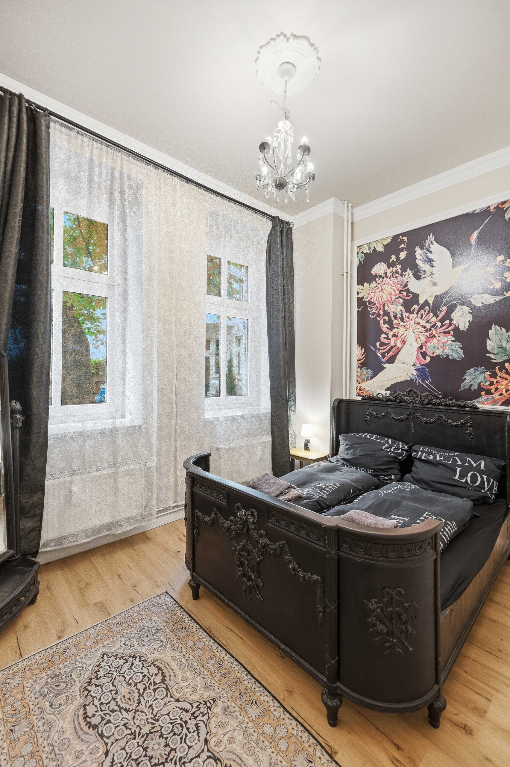 Wide bedroom view with ornate bed and chandelier