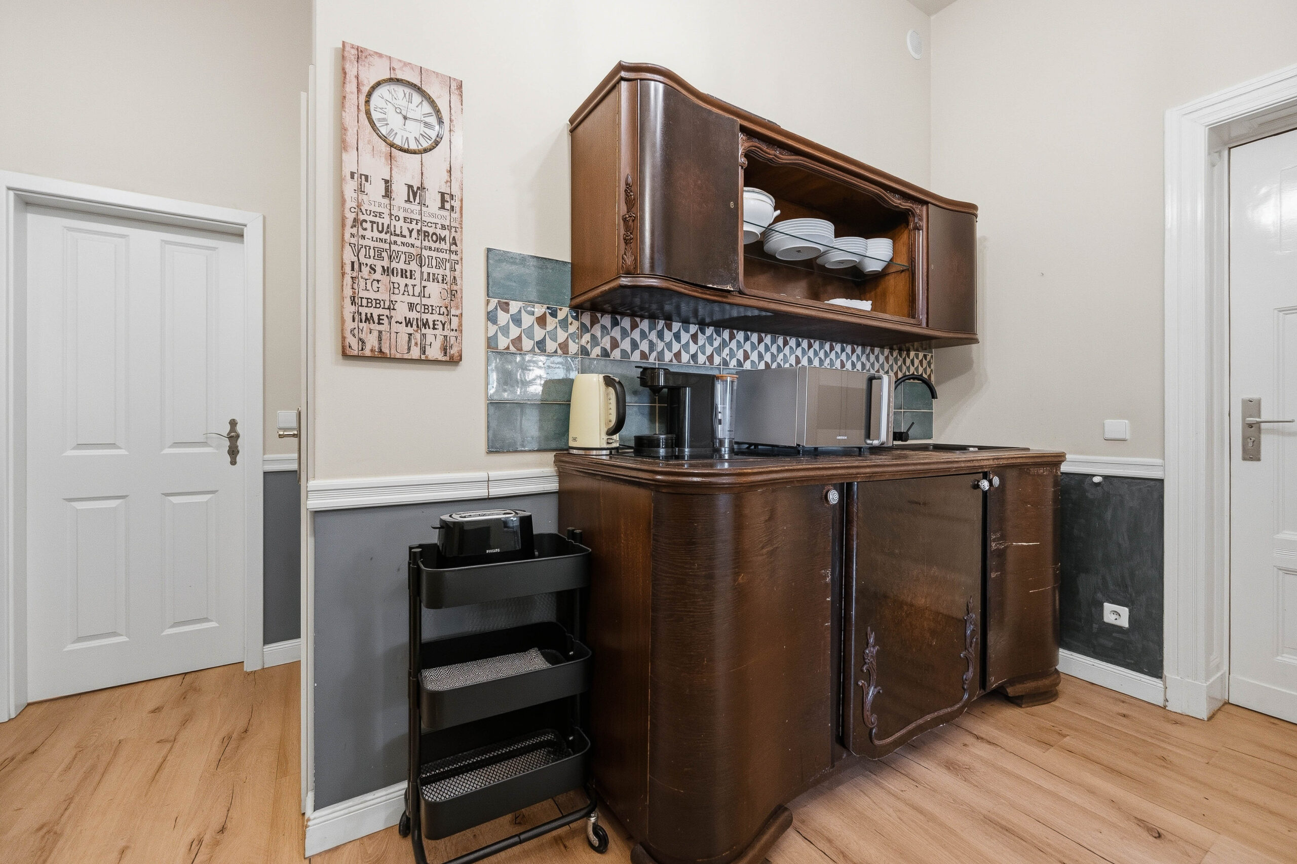 Wide kitchen view with wooden cabinetry and cart