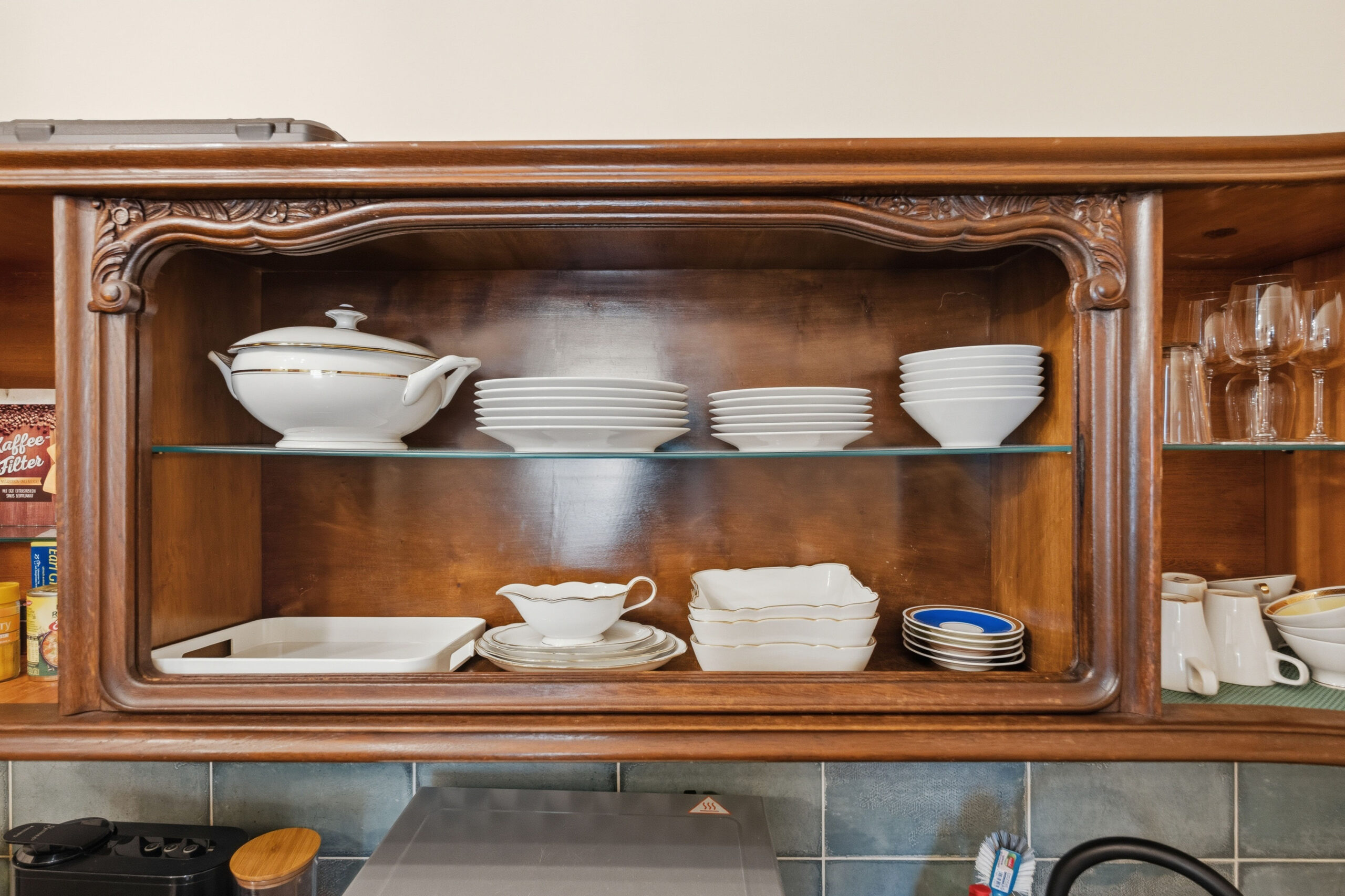 Shelf with stacked white dishware and tureen