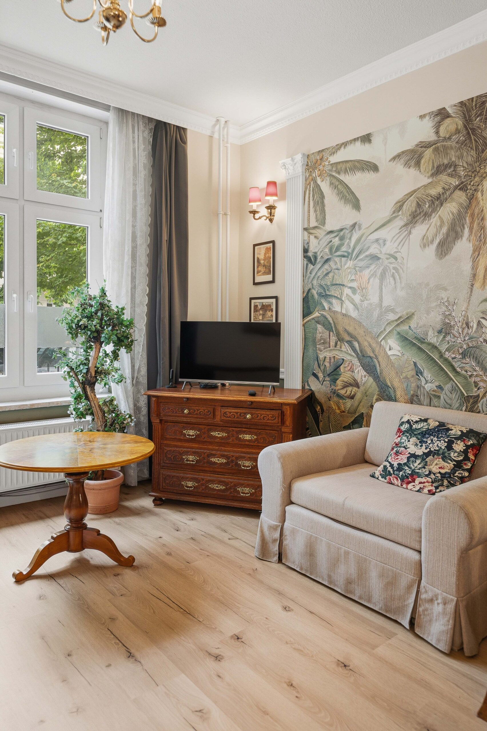 Armchair and round table near window with mural
