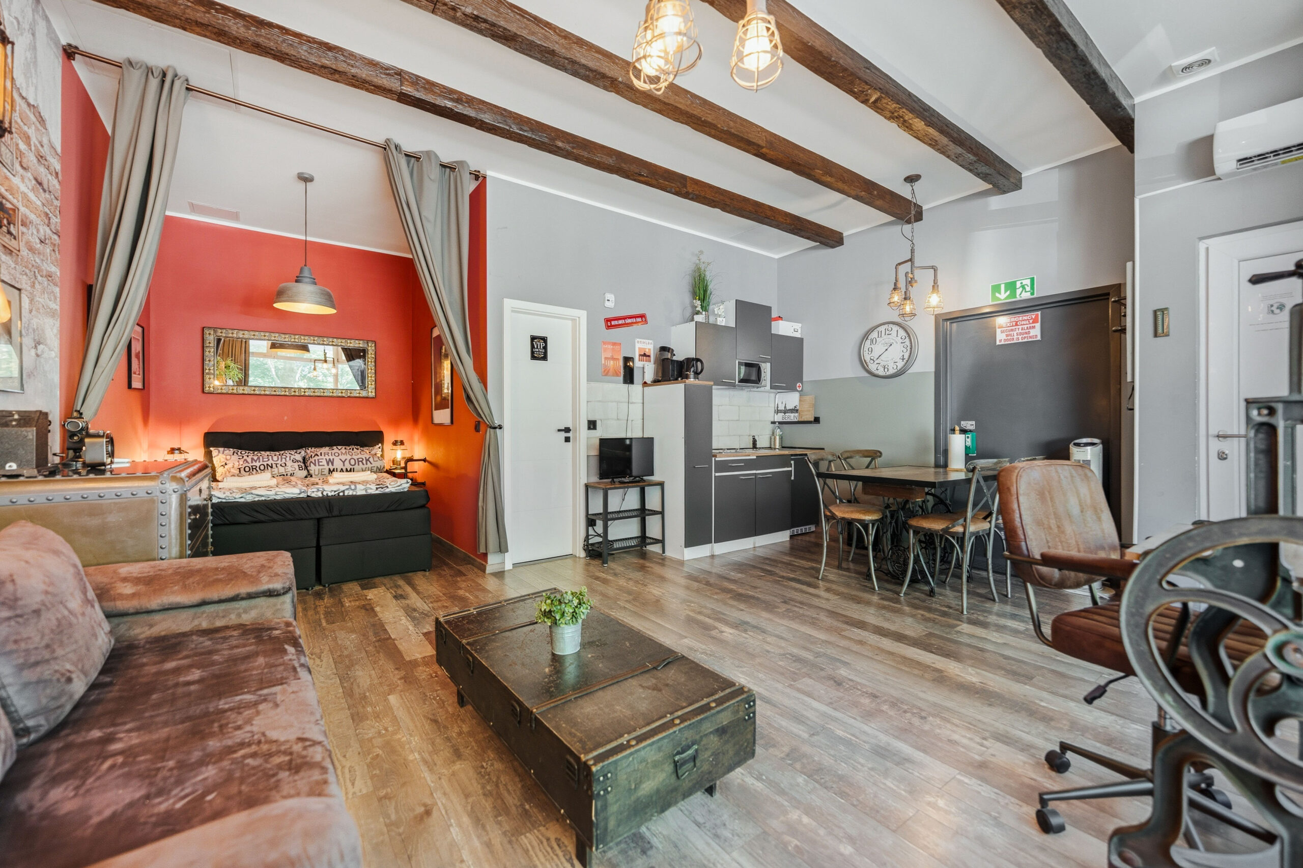 Open-plan living area with red accent wall and kitchen