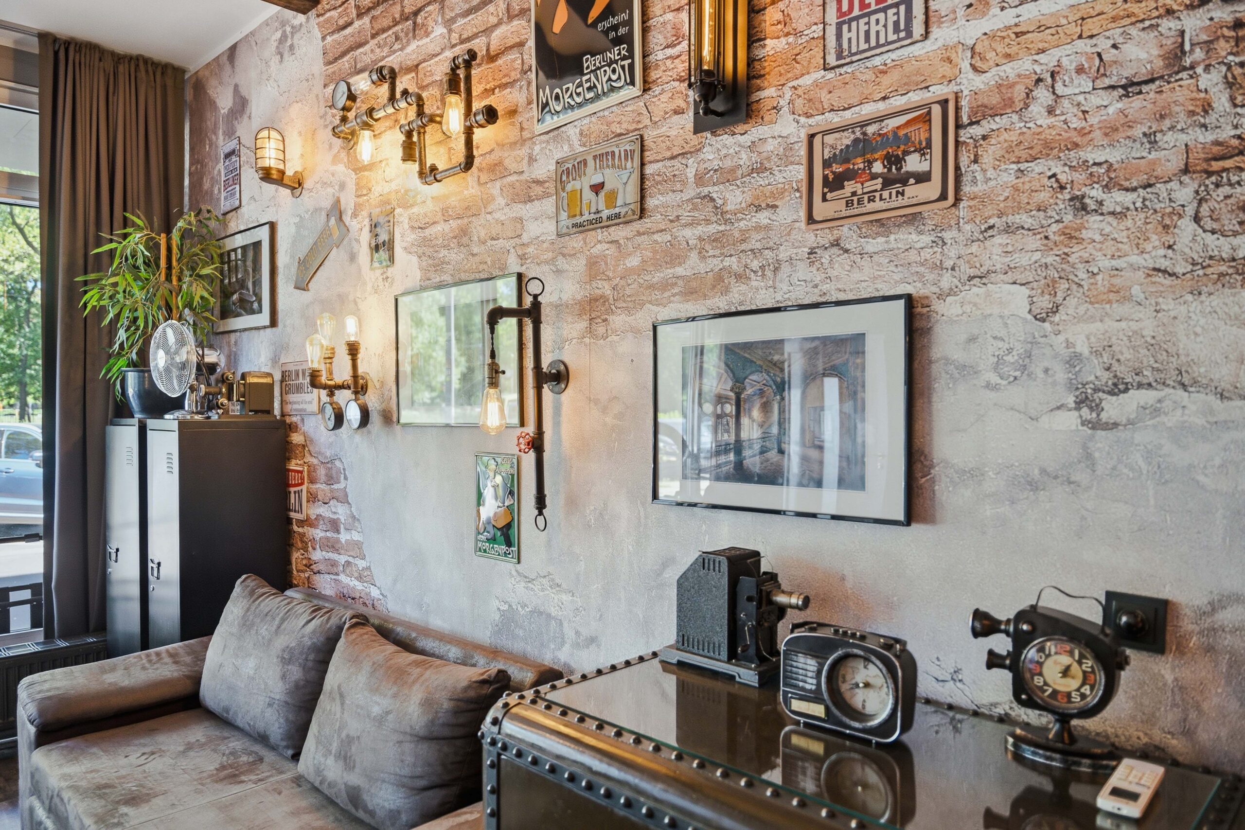 Sofa facing brick wall with framed artwork collection