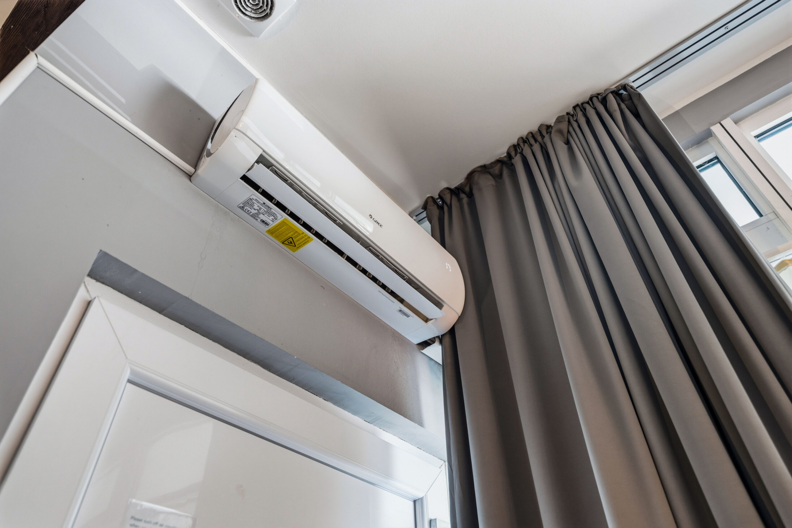 Wall-mounted air conditioner near curtain and door