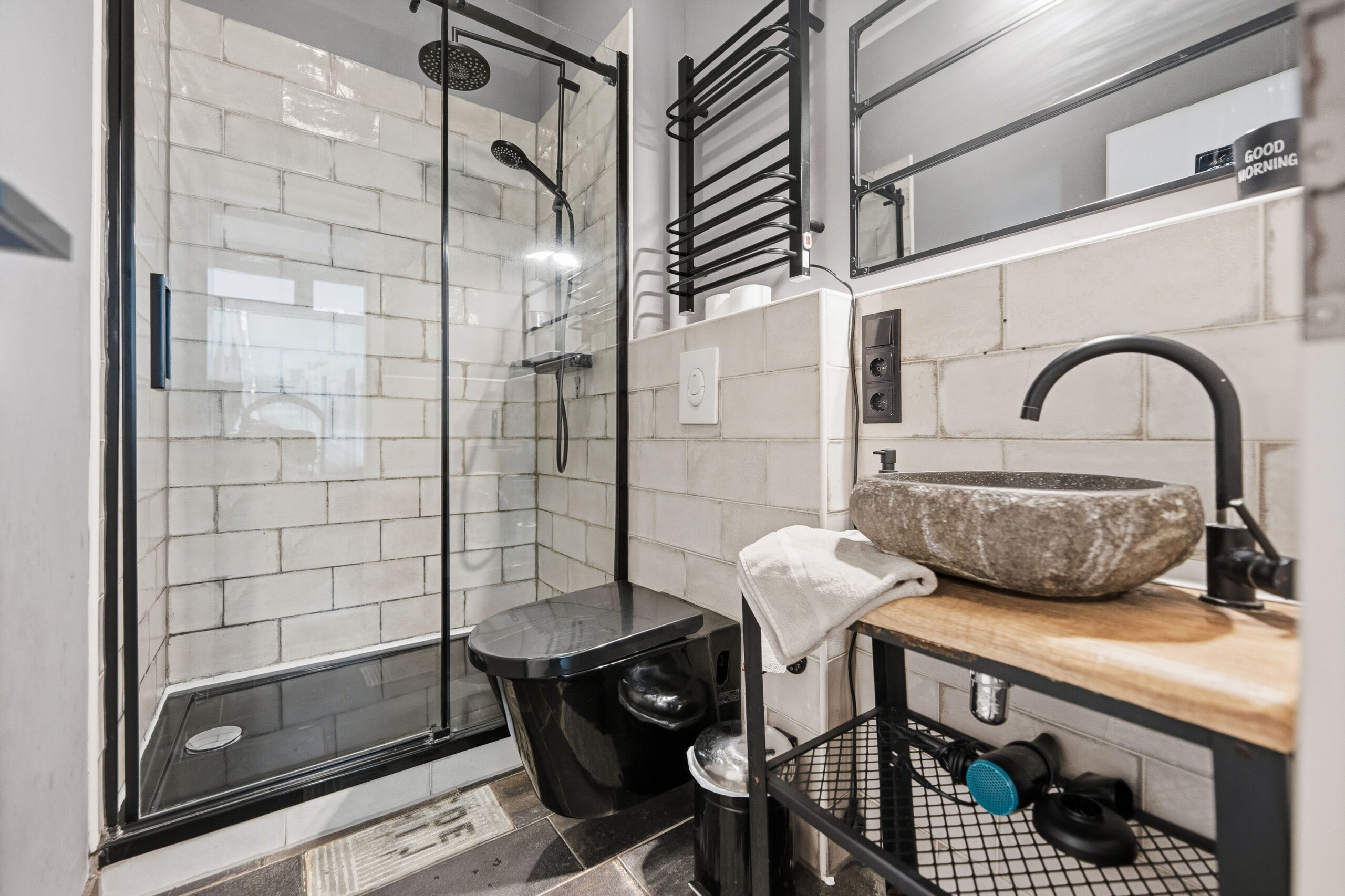Bathroom with glass shower, toilet and stone sink