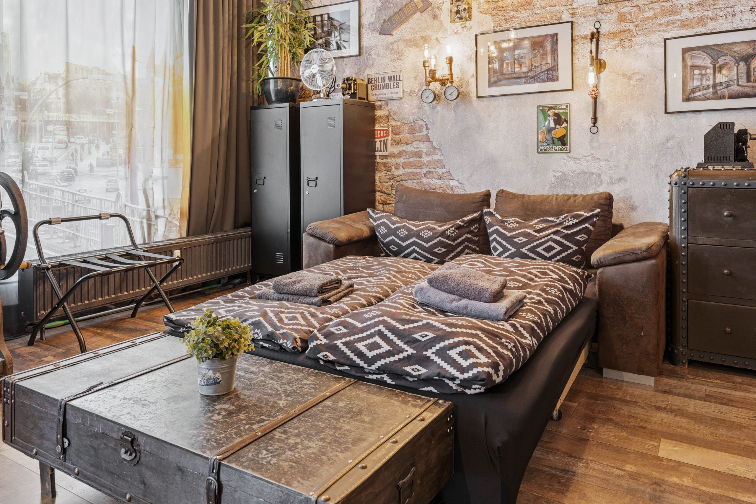 Bed with leather headboard and rustic trunk table
