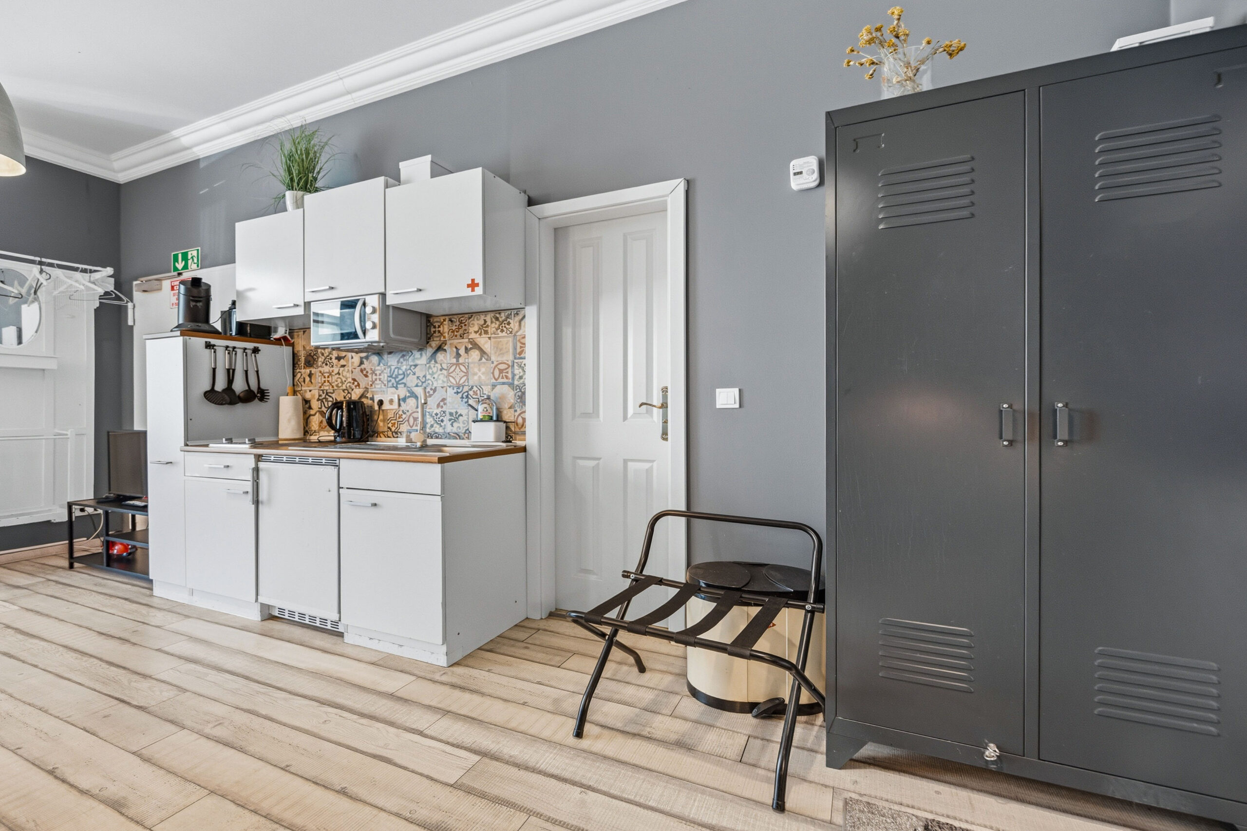 Kitchen with white cabinets and dark storage closet