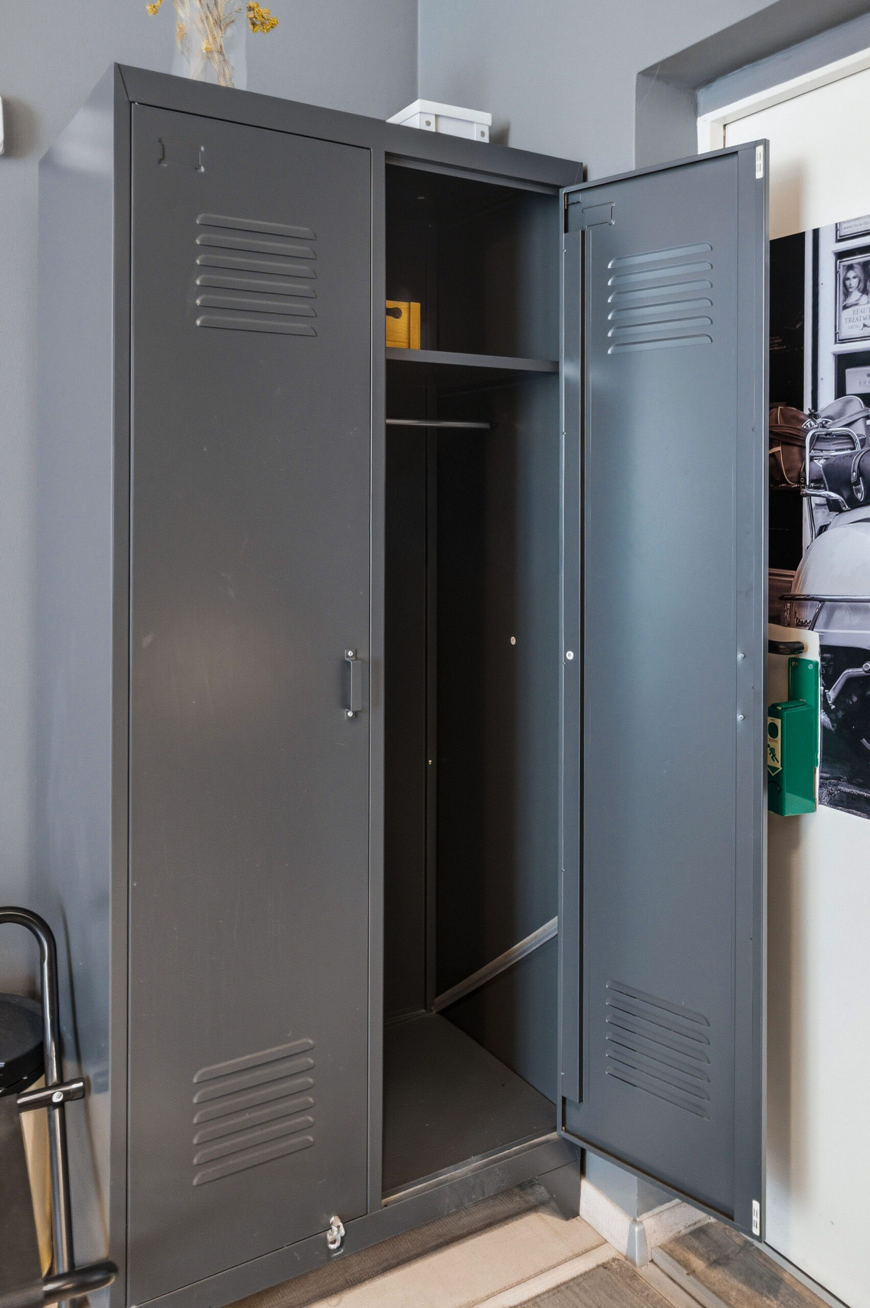 Open gray metal locker with hanging rod