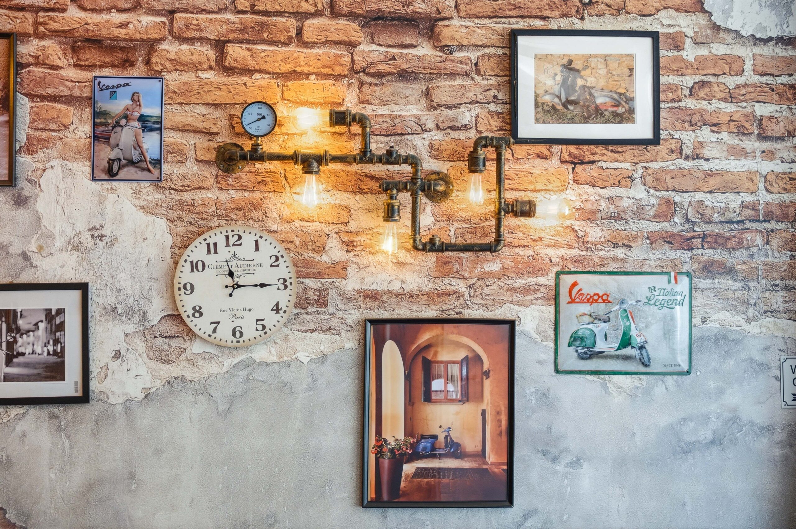 Brick wall decorated with framed art and industrial lights