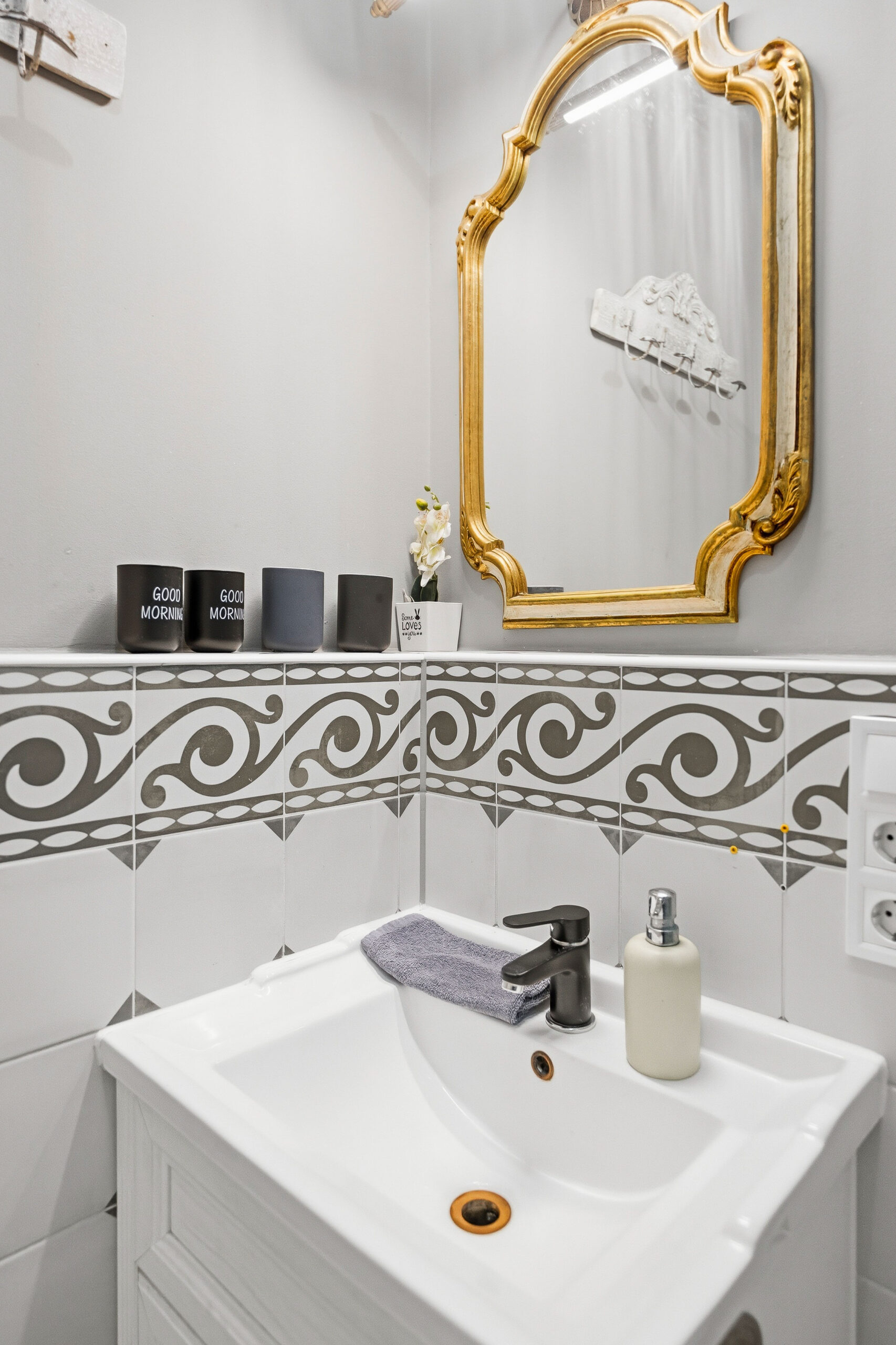 Bathroom sink with ornate gold mirror