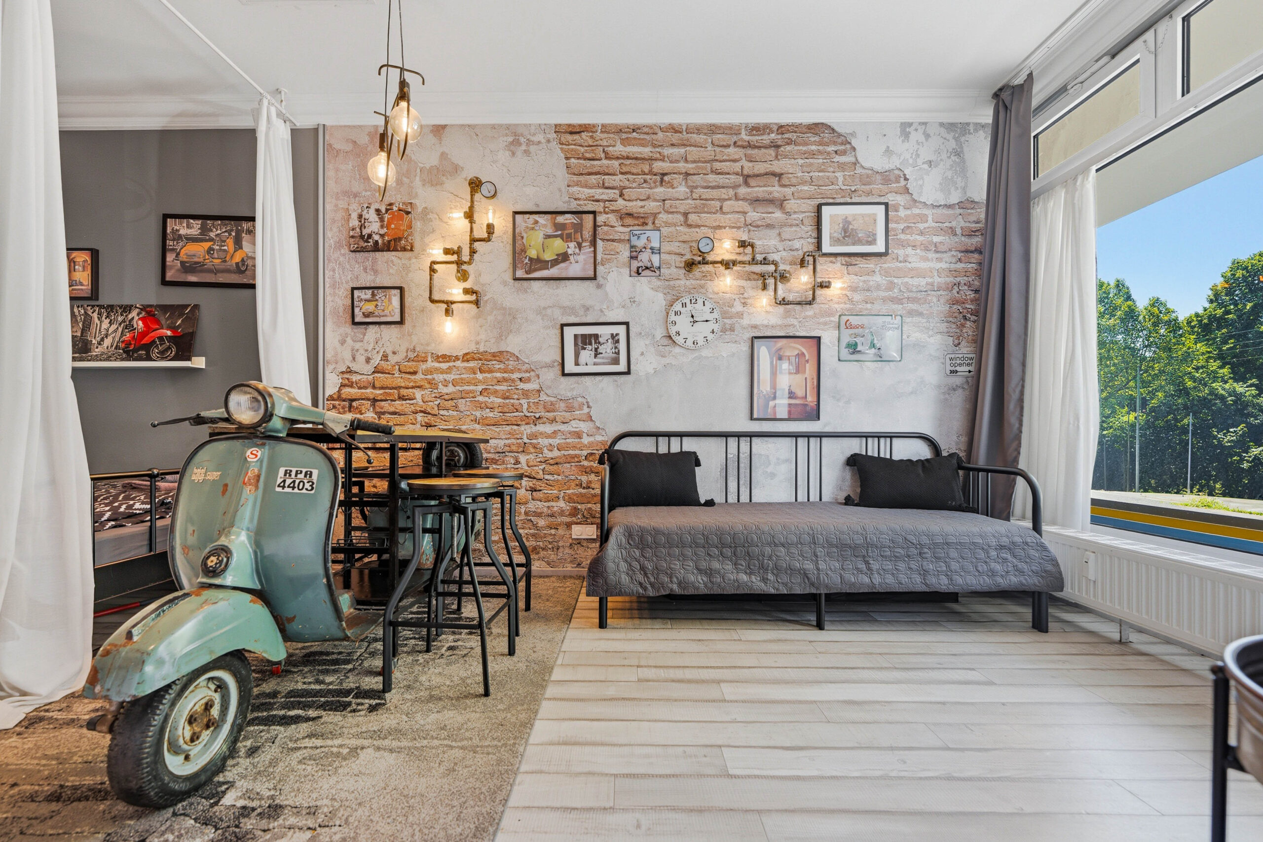 Bright living area with scooter, sofa and large window