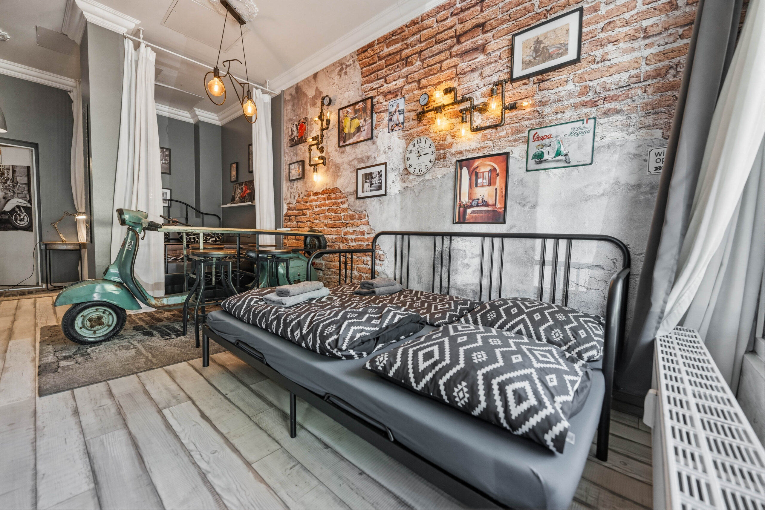 Daybed sofa with patterned pillows near brick wall
