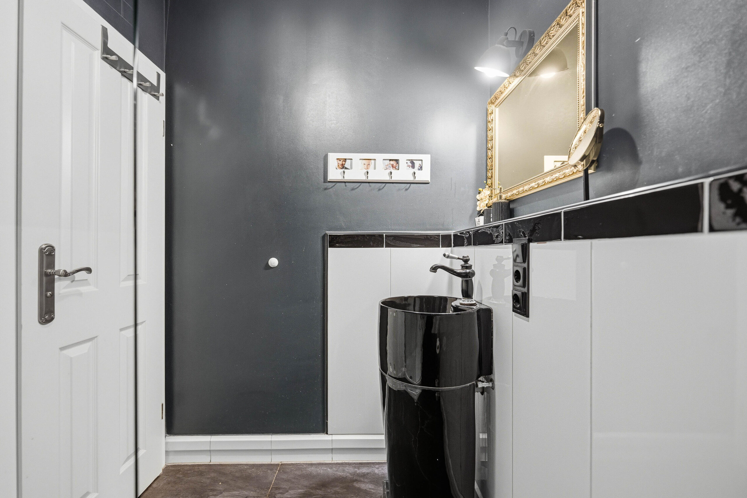 Bathroom sink area with gold mirror and tiles