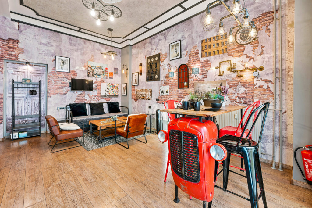 Open loft space with sofa, red table, exposed brick walls