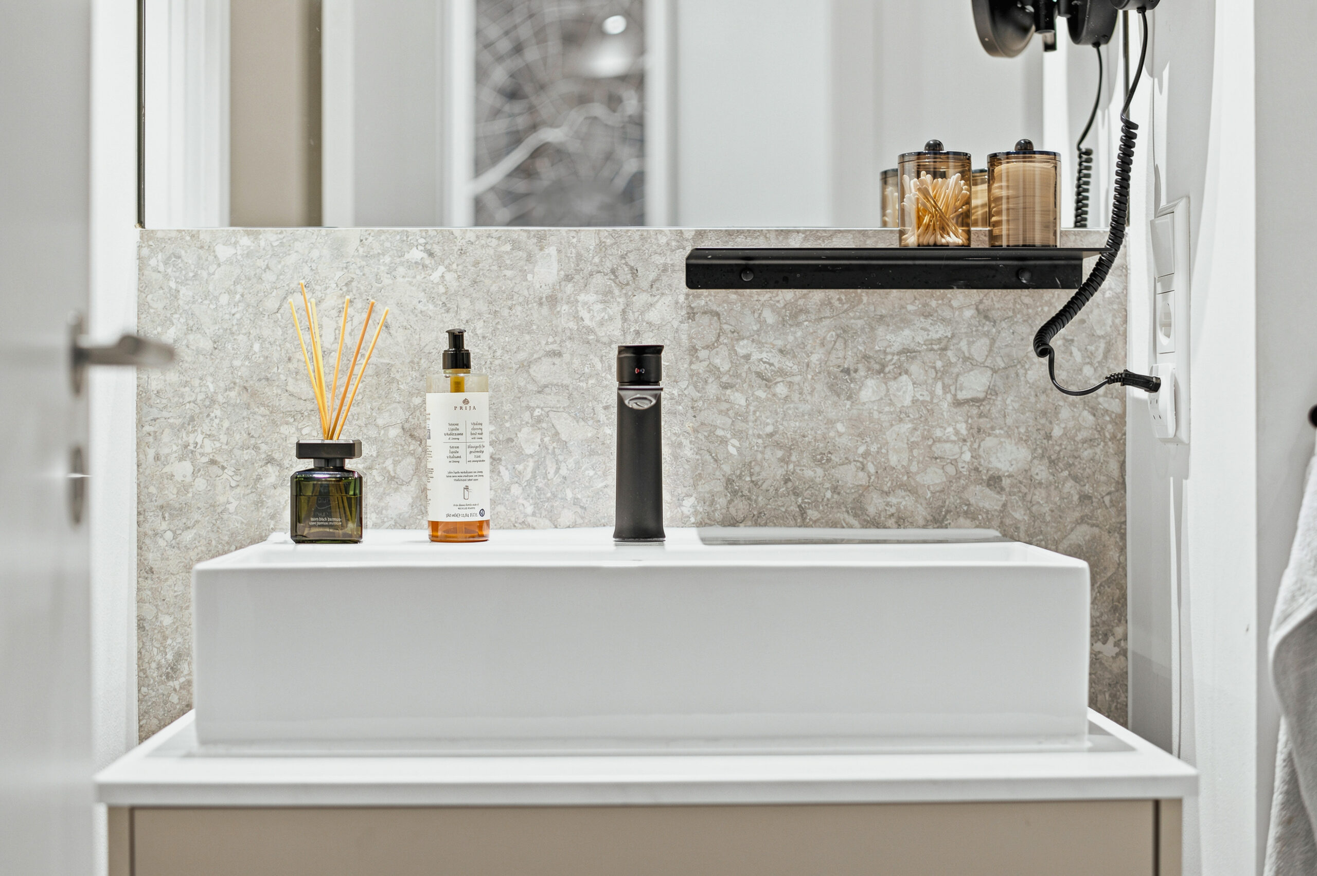 Minimalist bathroom sink with dark shelf and mirror