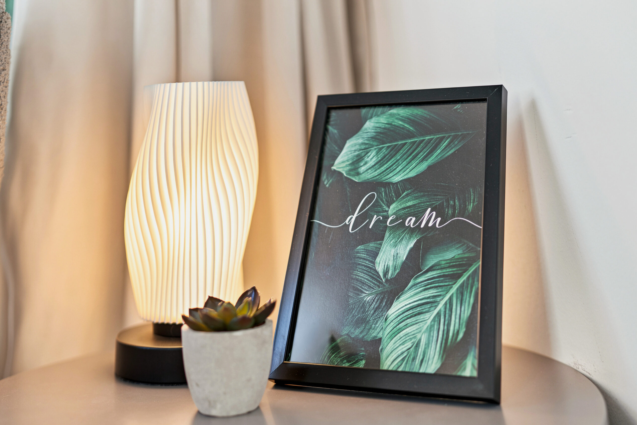 Bedside table with lamp and framed plant artwork