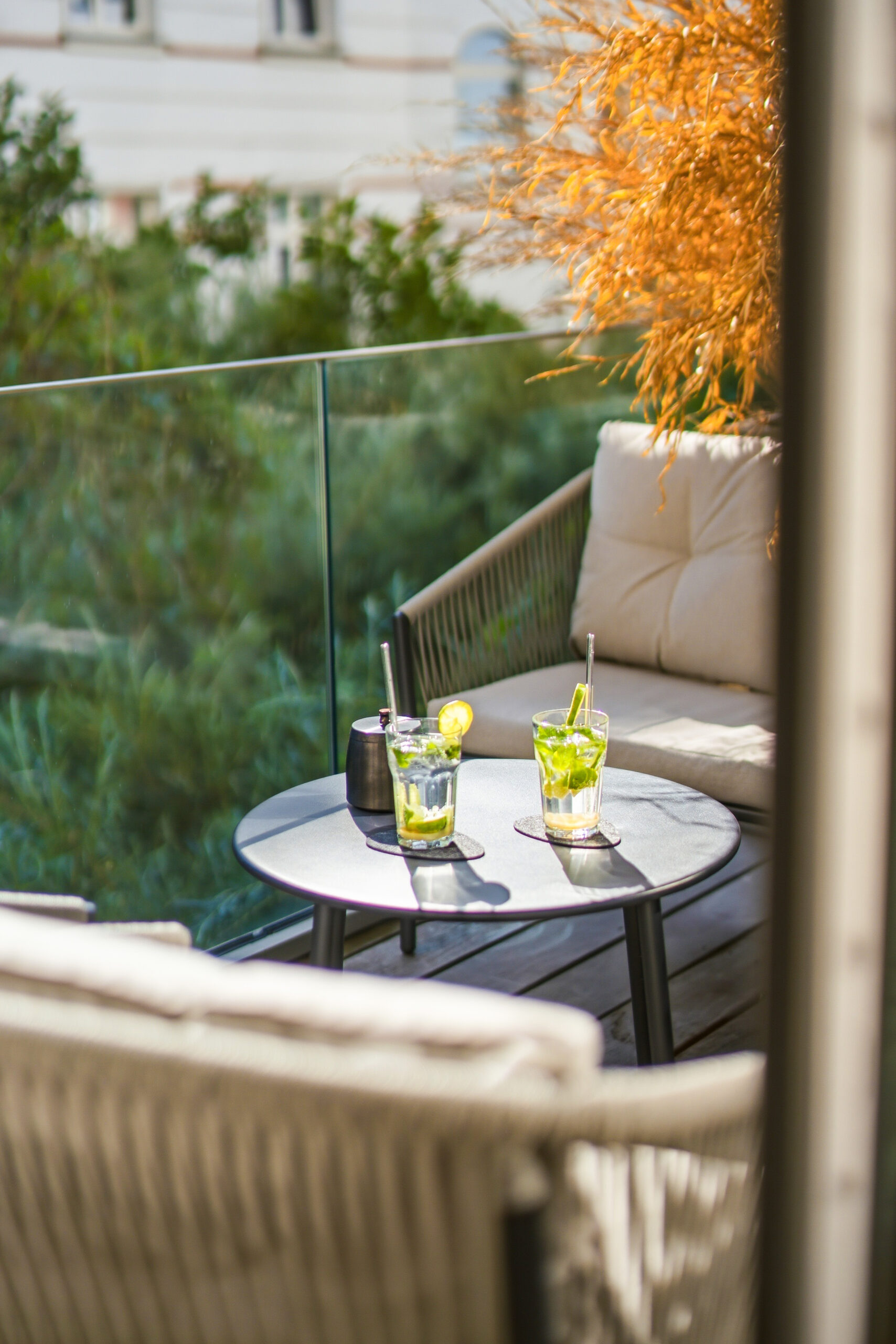 Corner balcony with modern seating, table, and autumn foliage