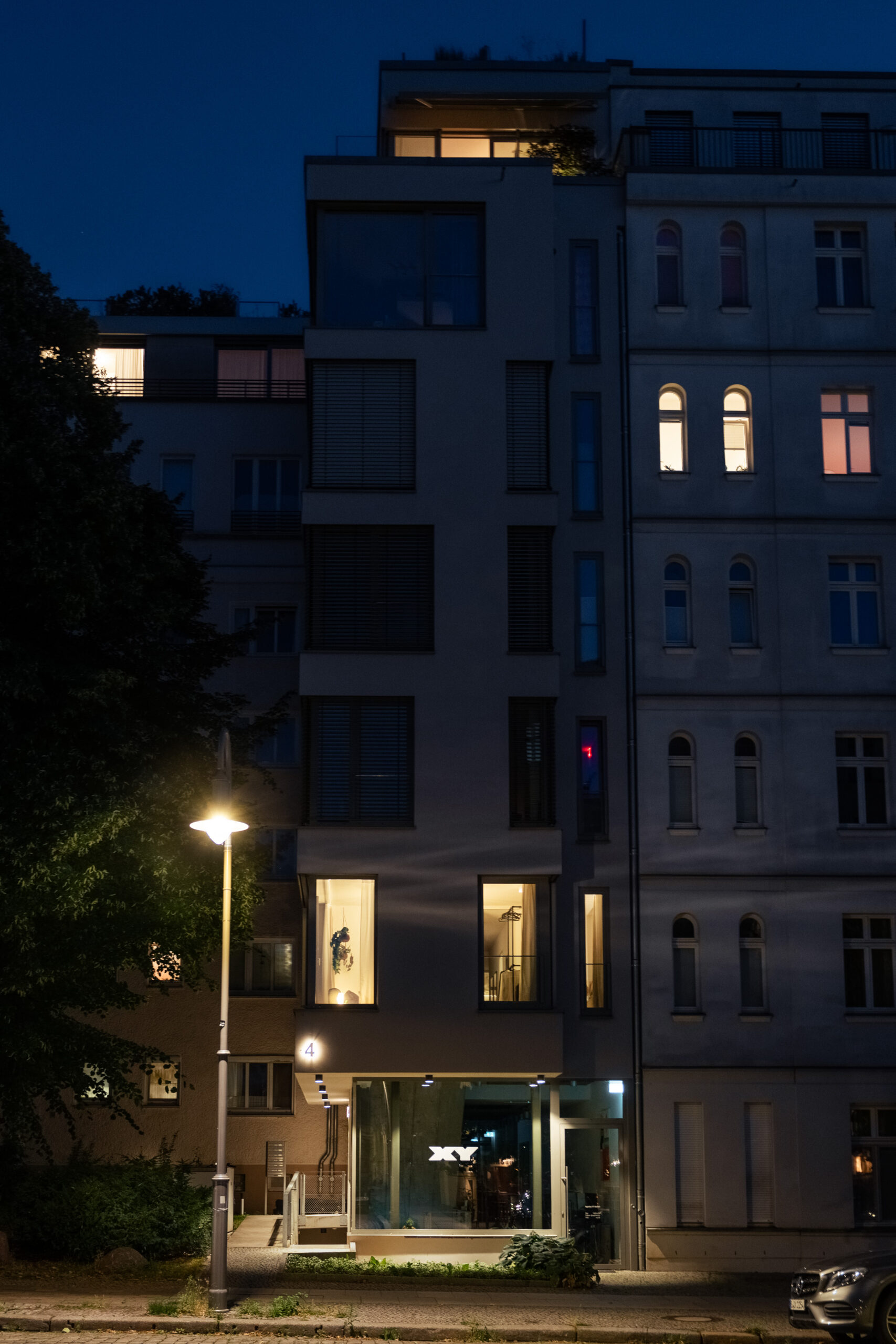 Modern apartment building facade at dusk with warm lighting
