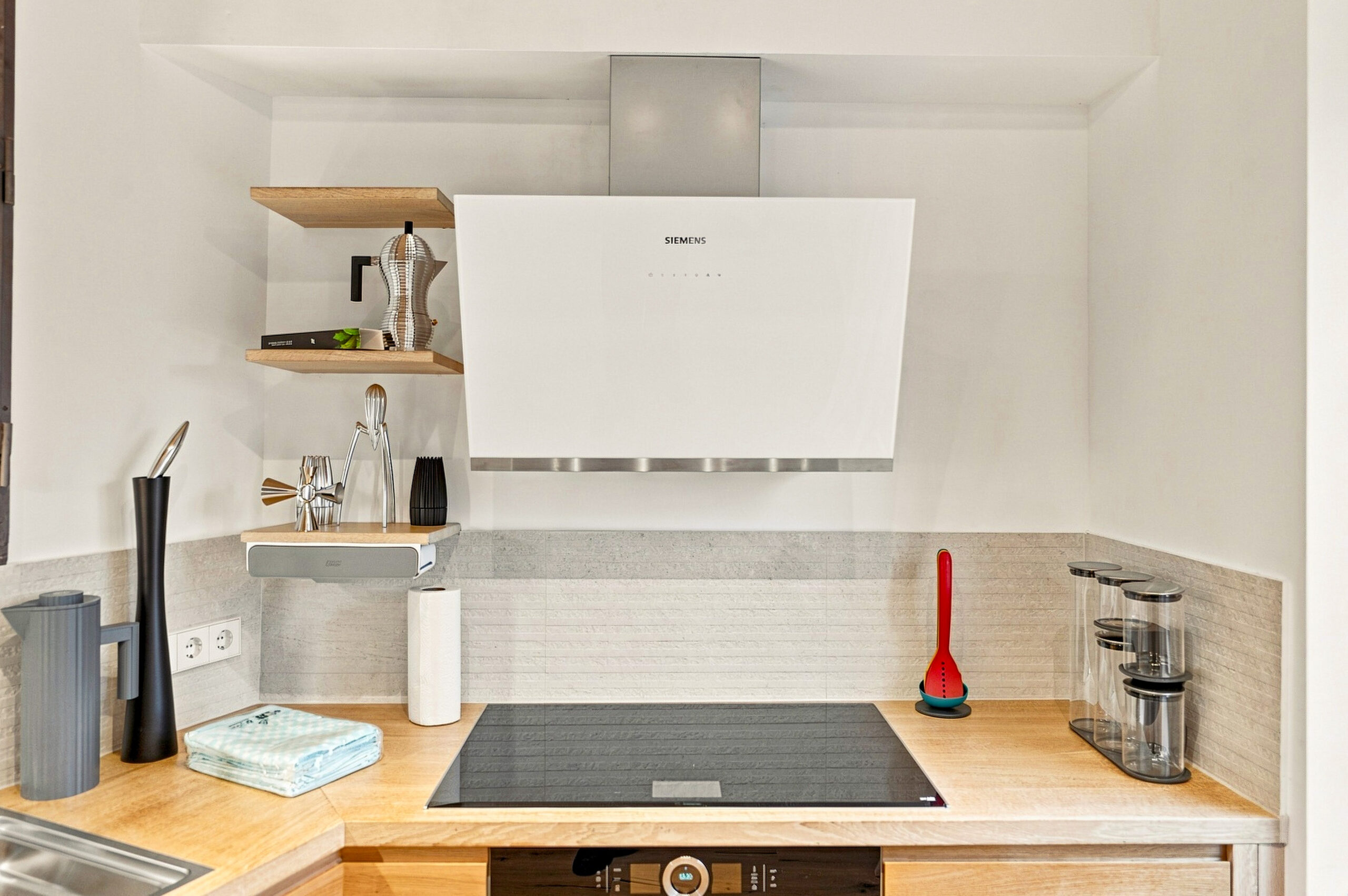Compact kitchen counter with stove, shelving and minimal appliances