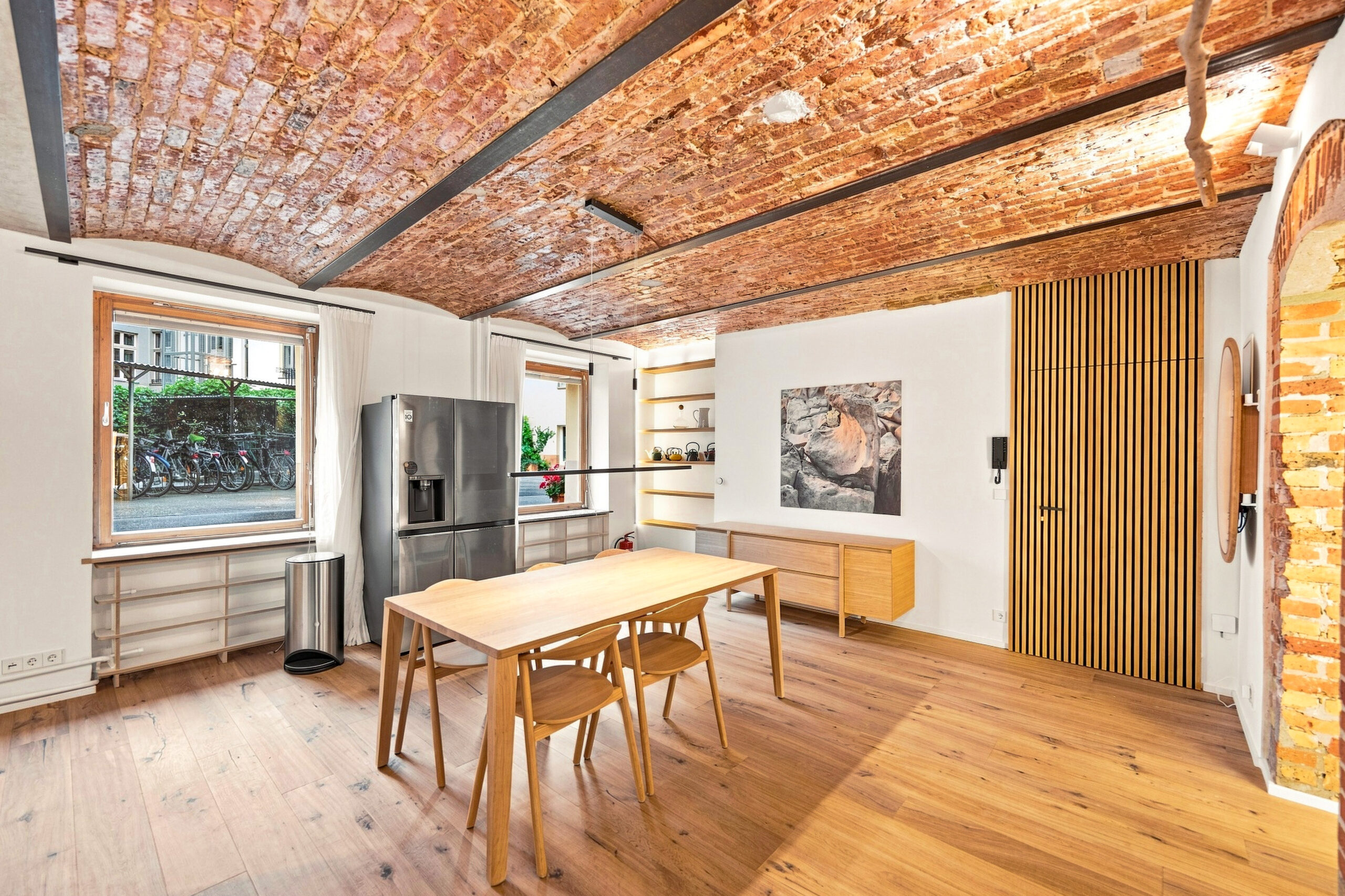 Modern kitchen with exposed brick, wooden dining table and island