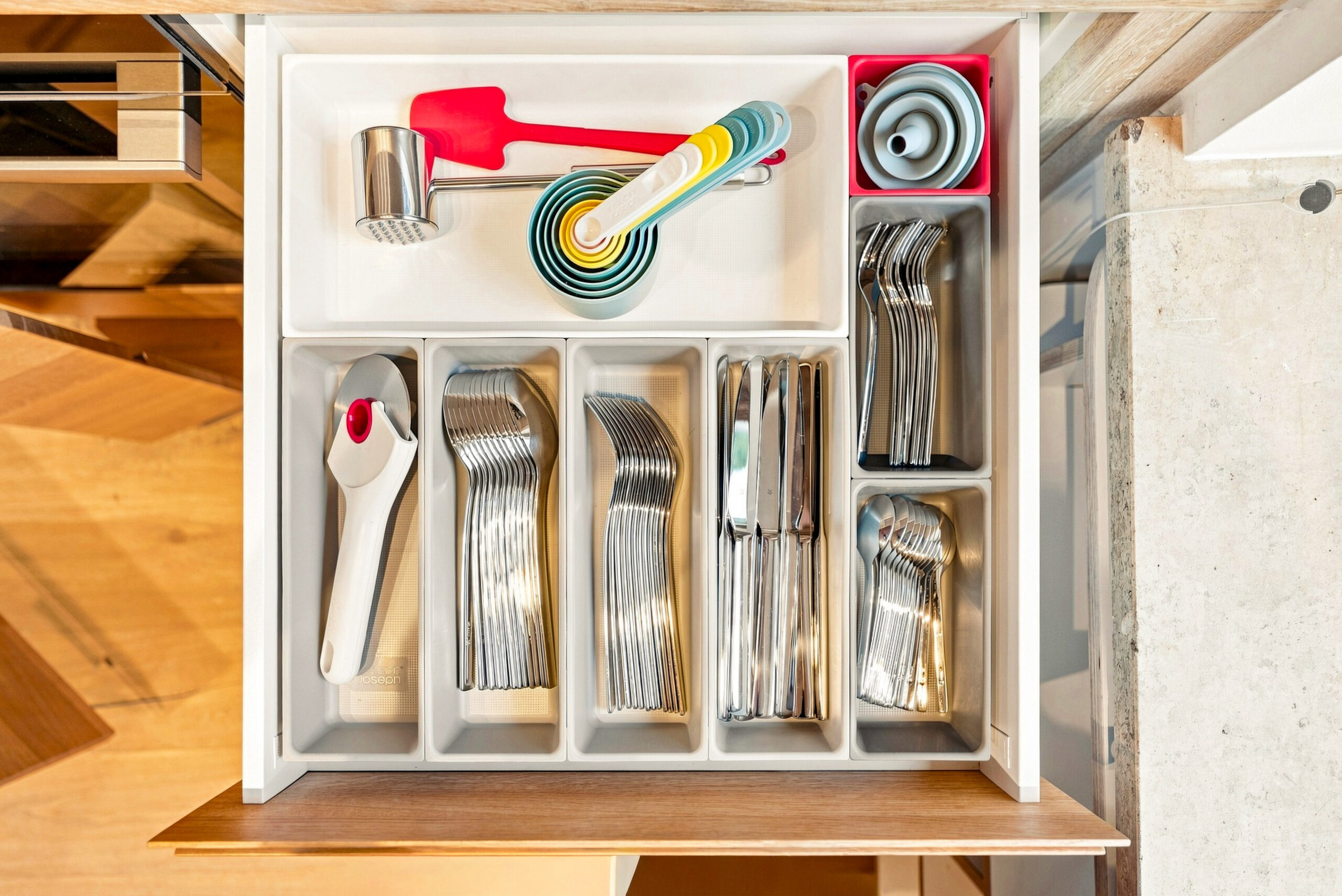 Open kitchen drawer displaying organized utensils and cooking tools