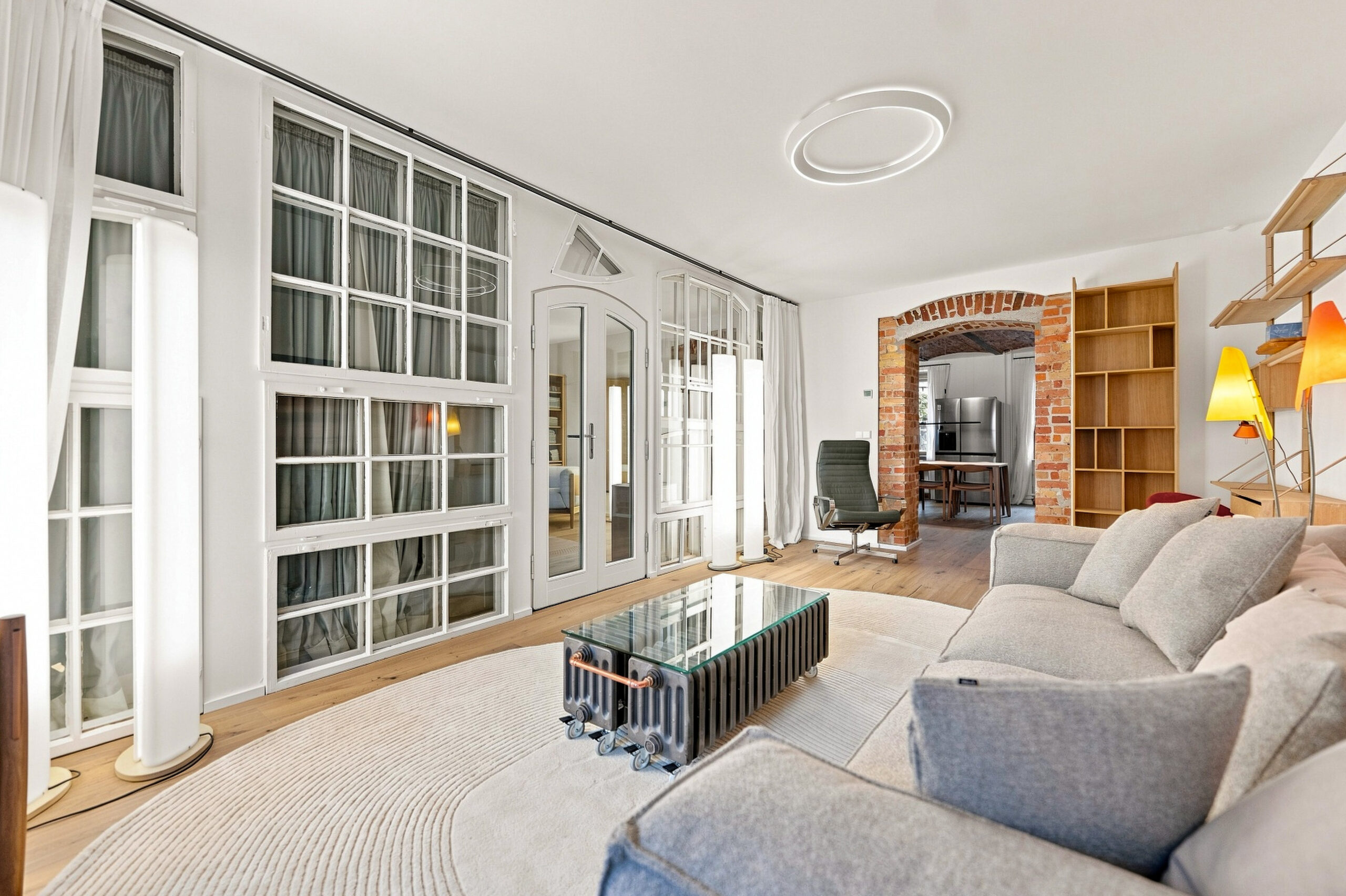 Large open-plan living area with glazed storage and grey sofa