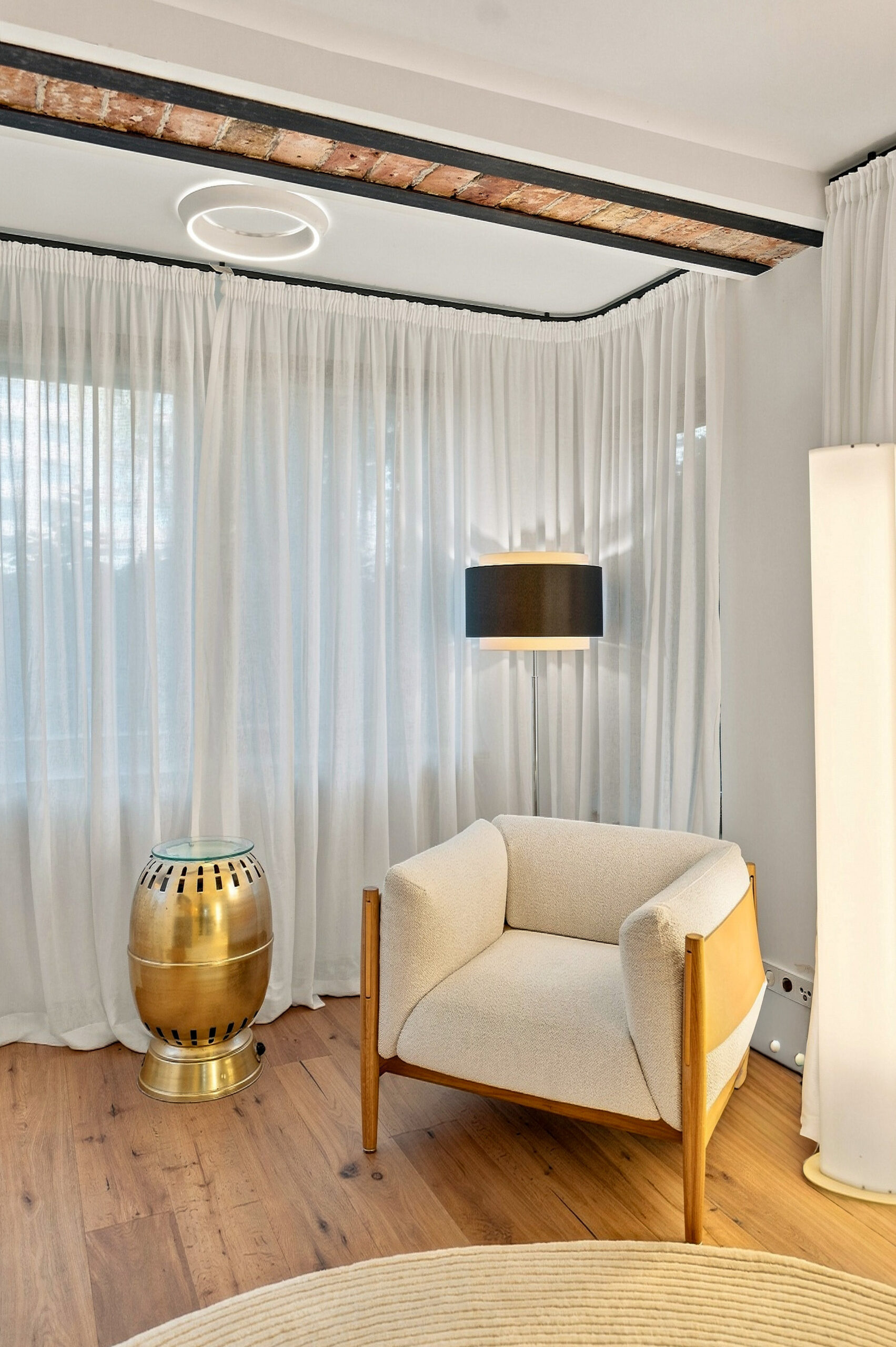 Minimalist sitting area with cream chair and golden accent table