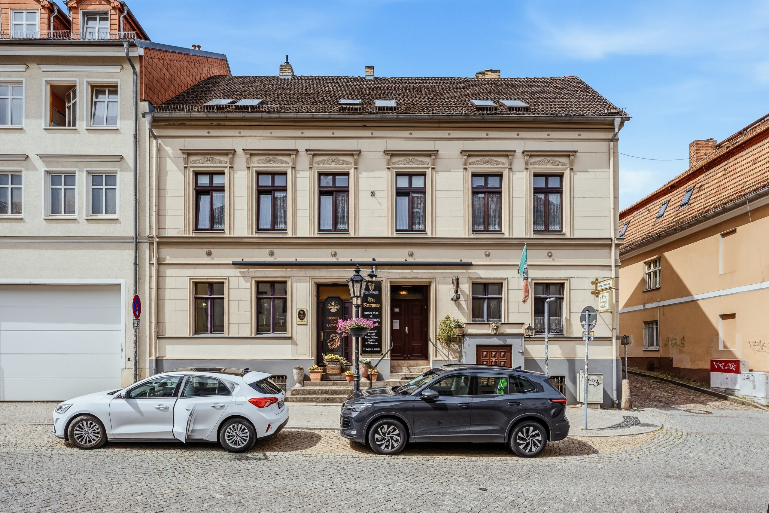 Front view of historic building facade with cars