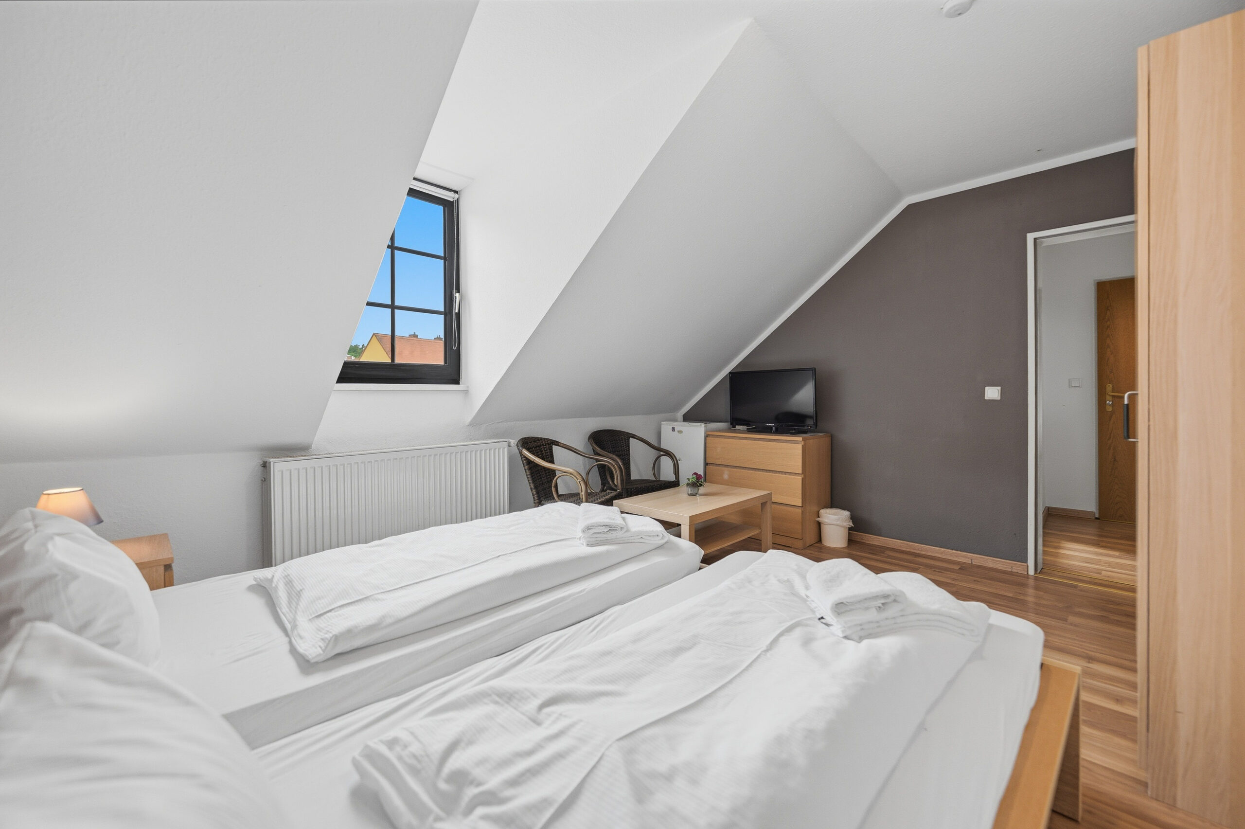 Attic bedroom with sloped ceiling and TV