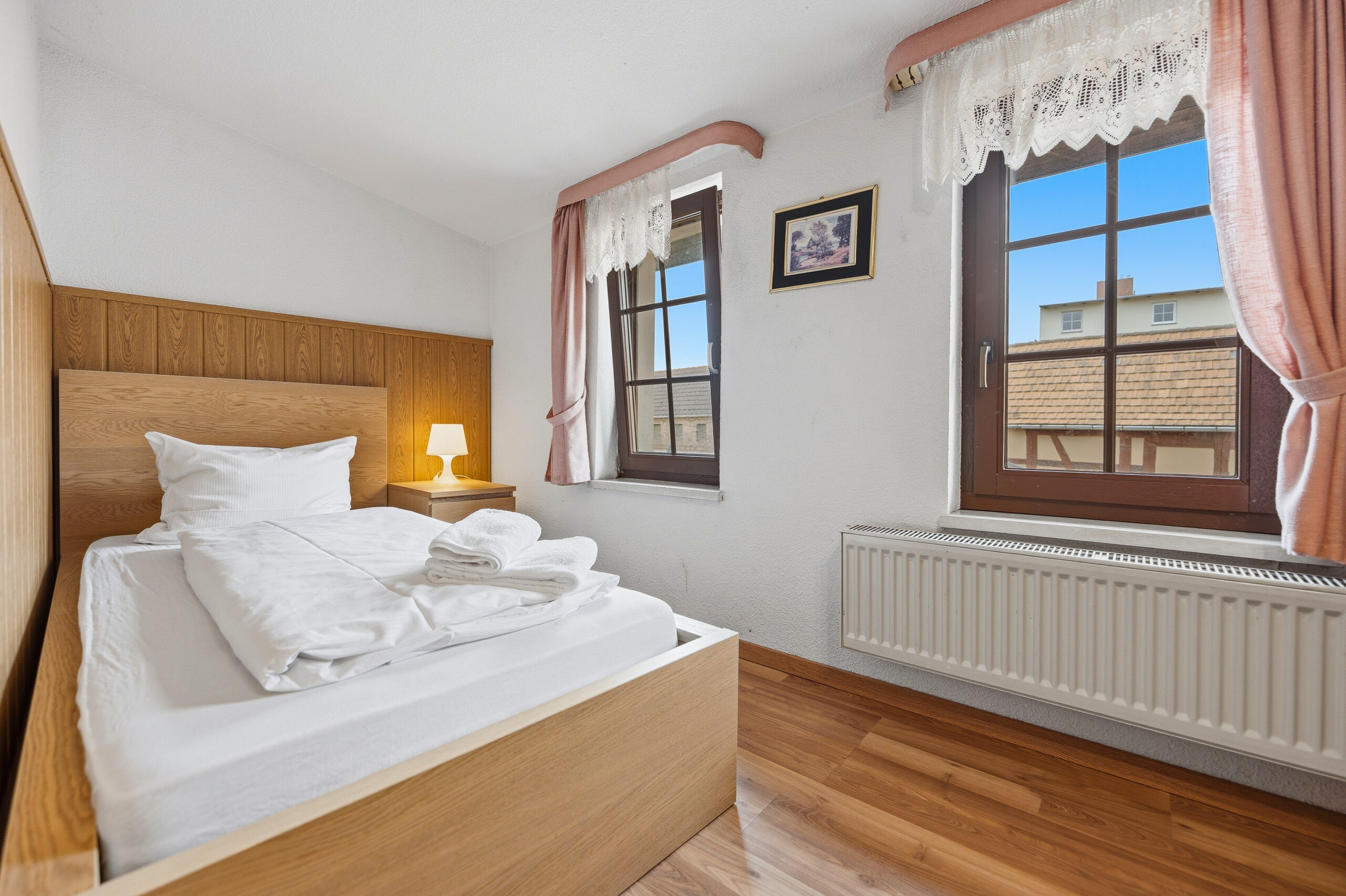 Cozy bedroom with wooden bed and windows