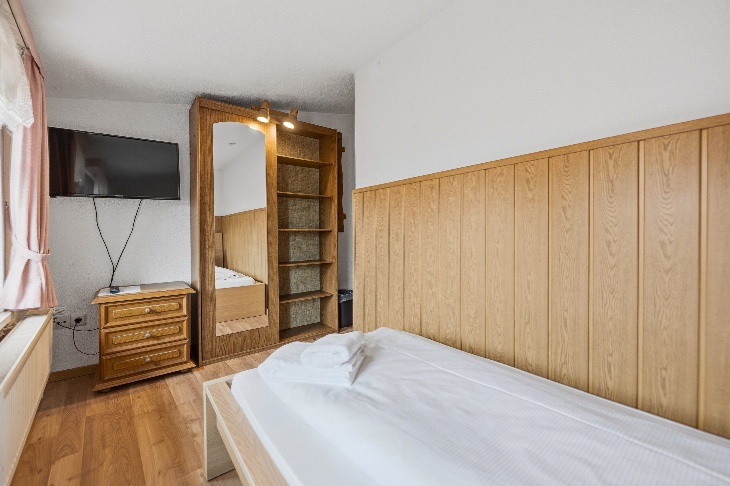 Bedroom with wood paneling and mirrored closet