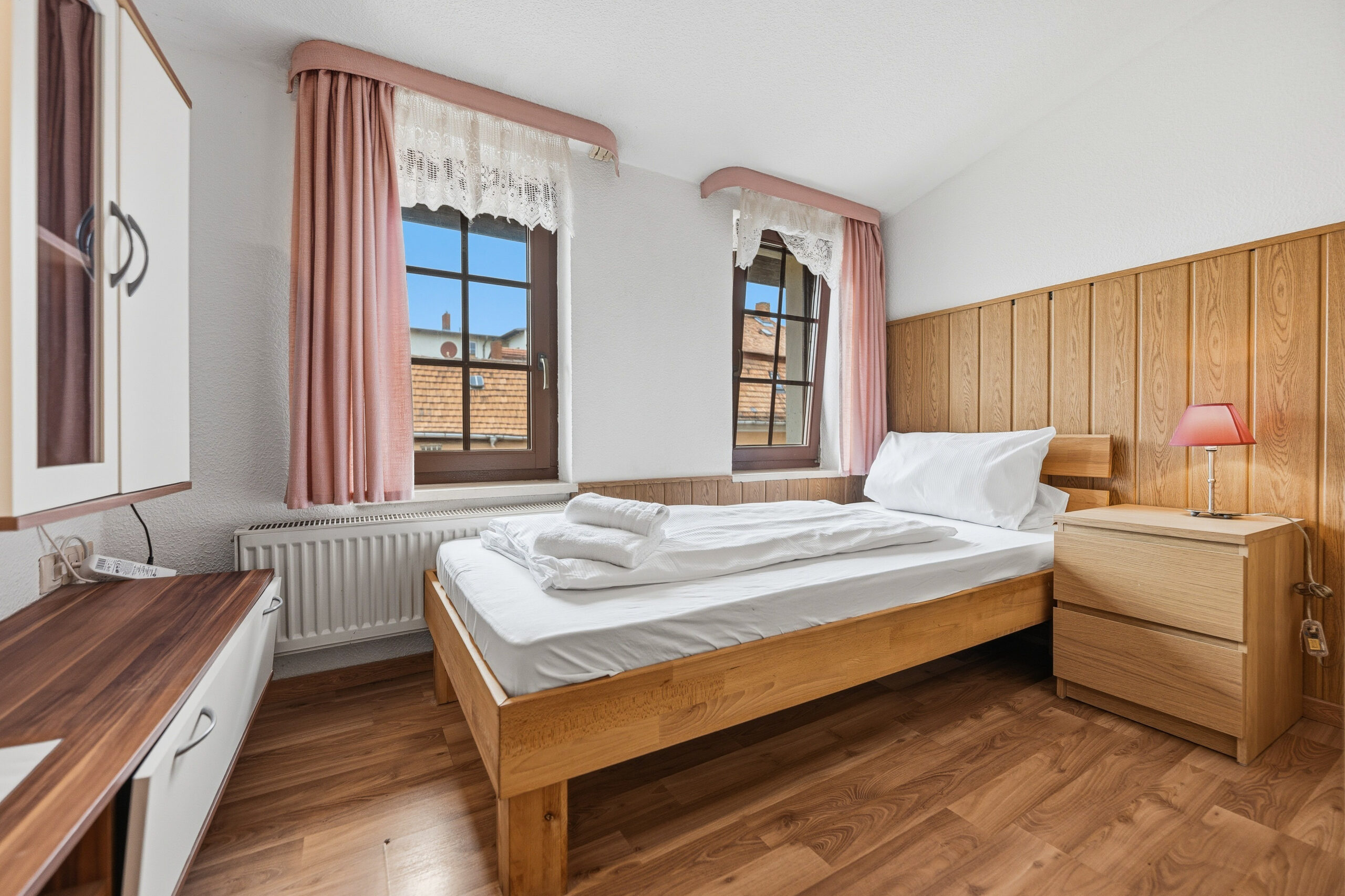 Wood paneled bedroom with two windows