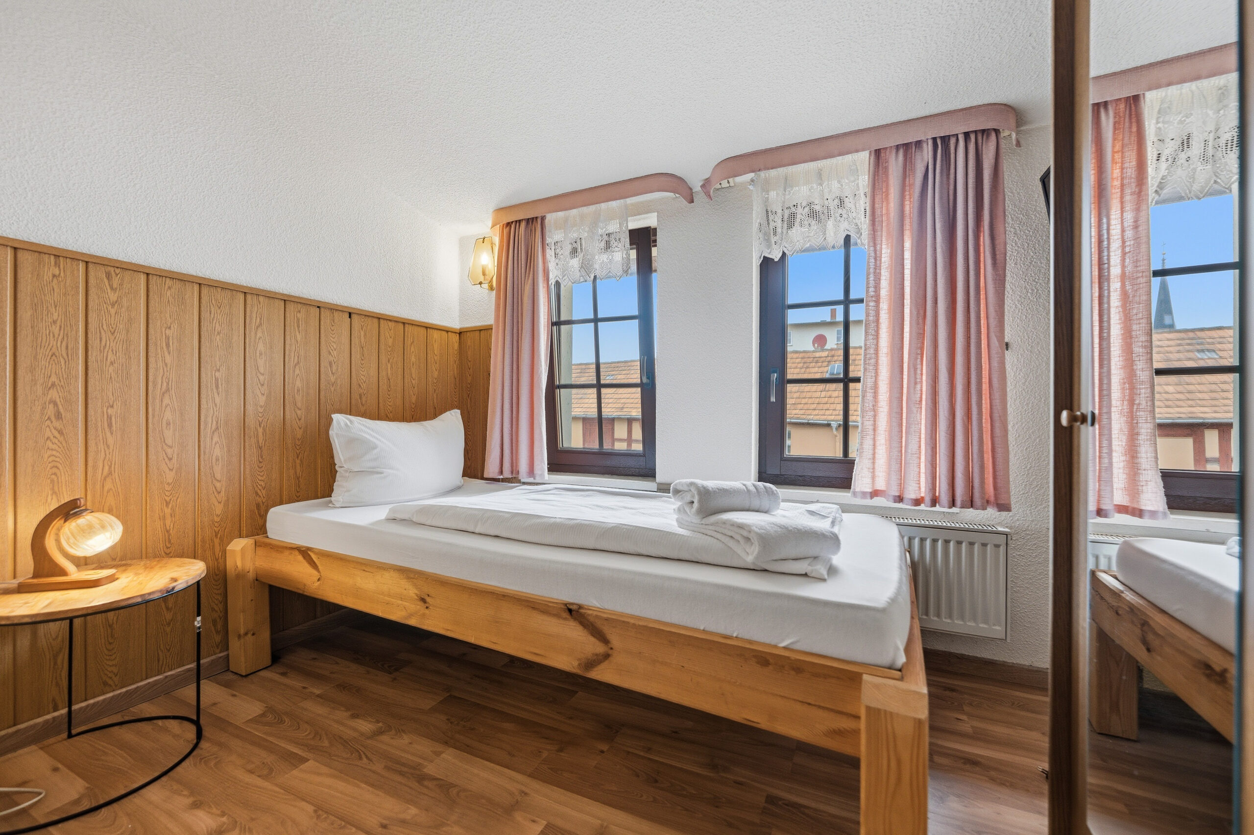 Cozy bedroom with wood paneling and windows