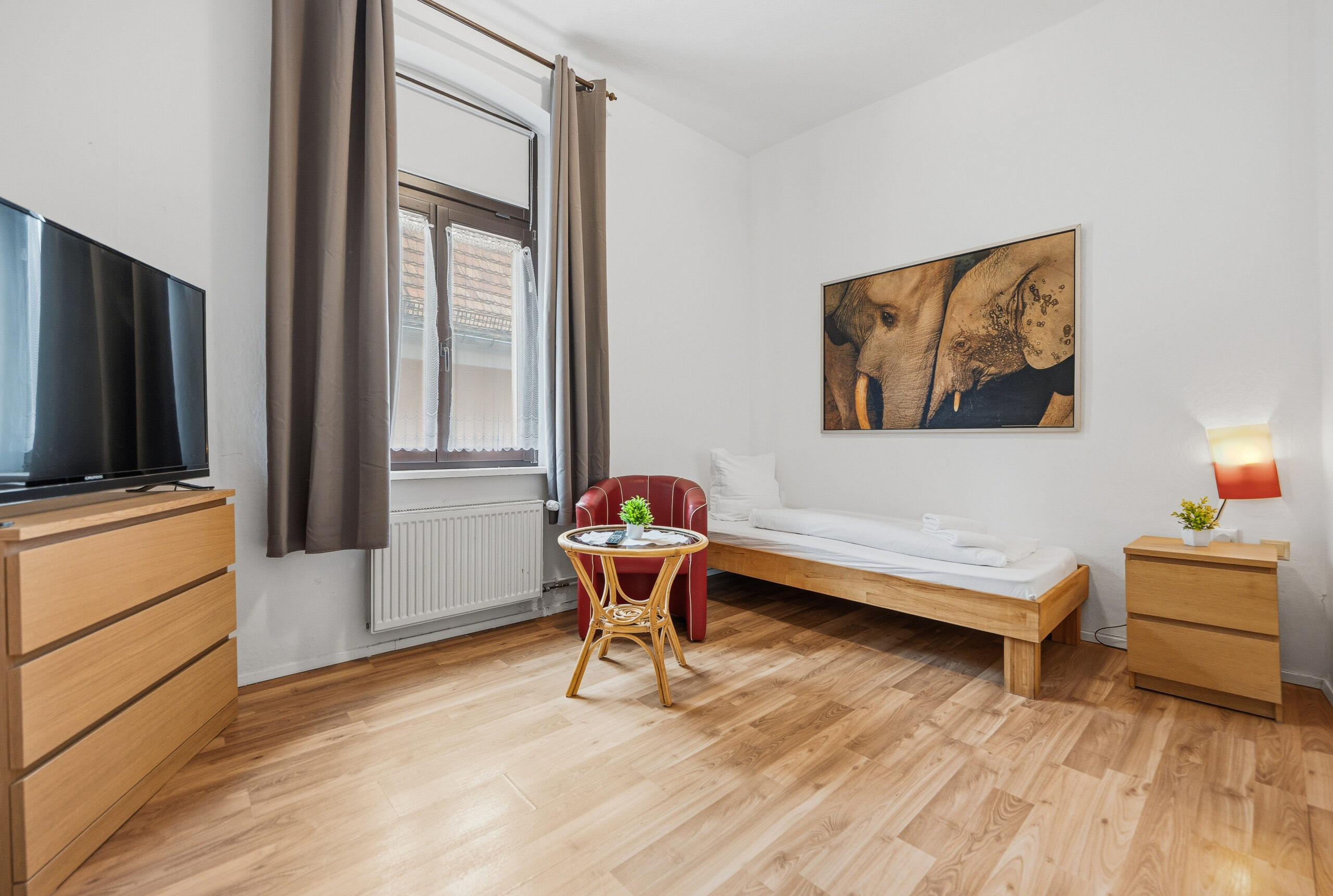 Single bed room with dresser and TV