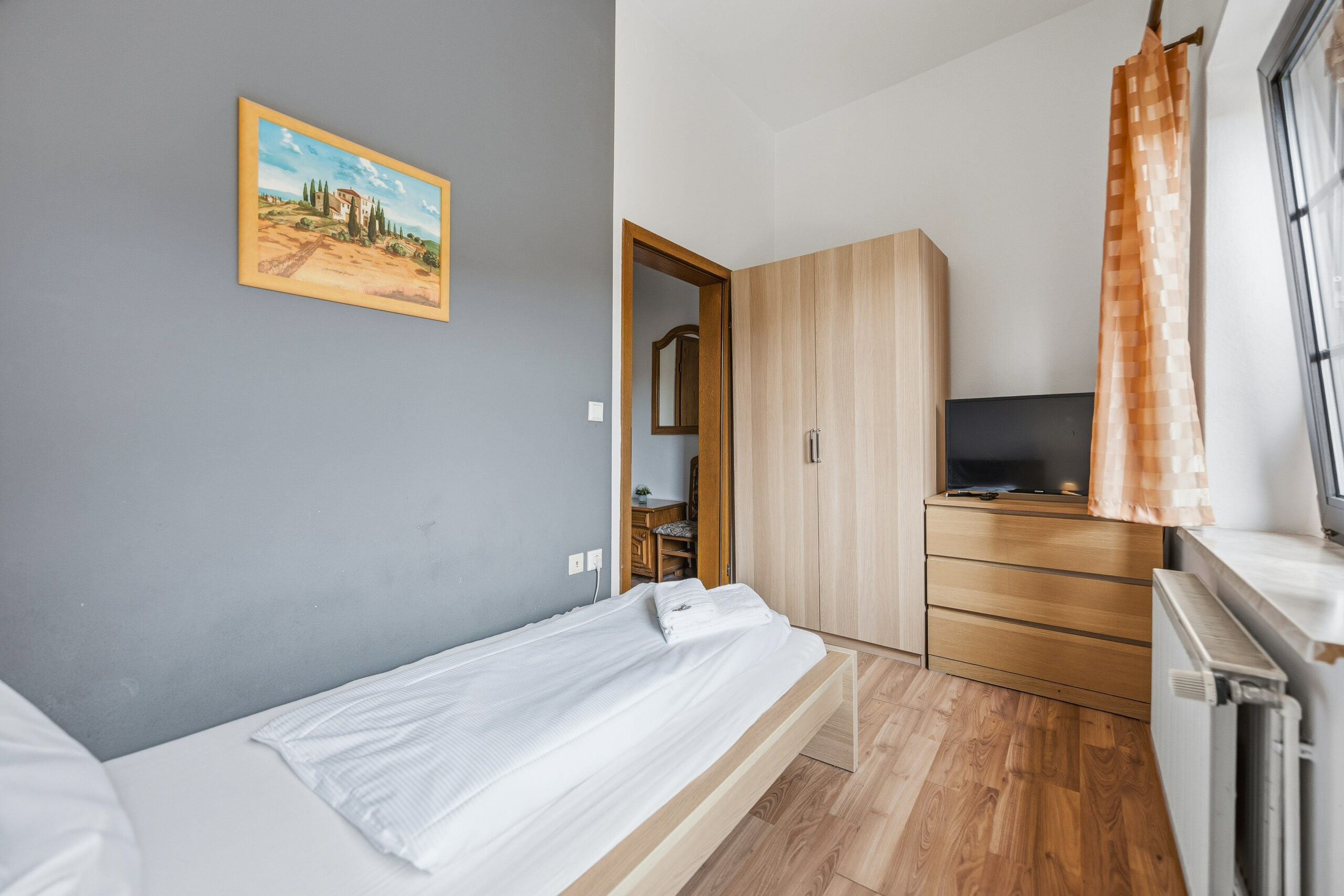Single bed with wardrobe and artwork