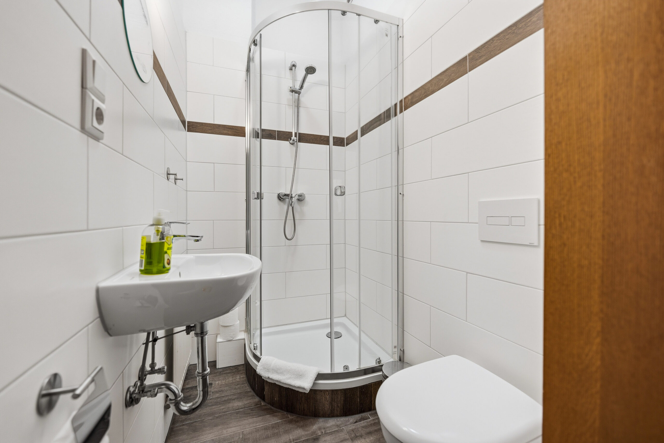 Corner shower bathroom with wood-look flooring