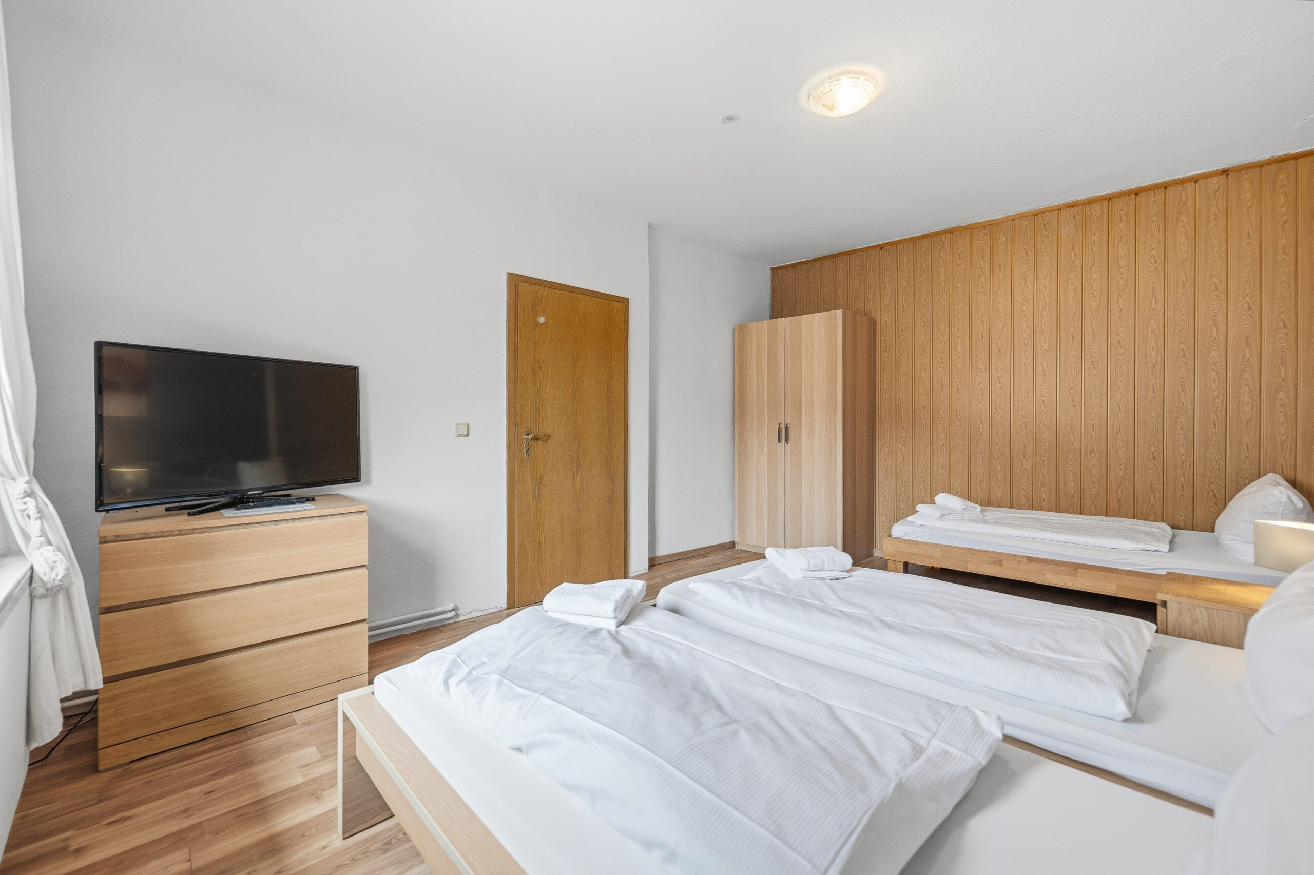 Twin beds with wooden panel wall