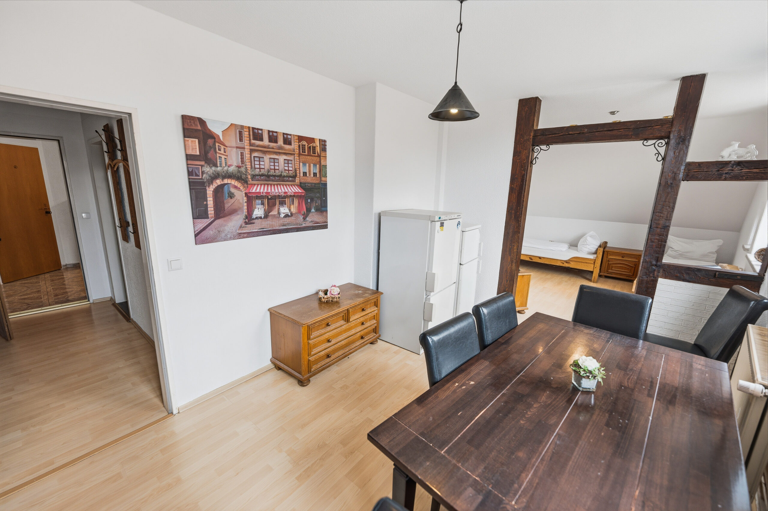 Dining table with wooden beams and artwork