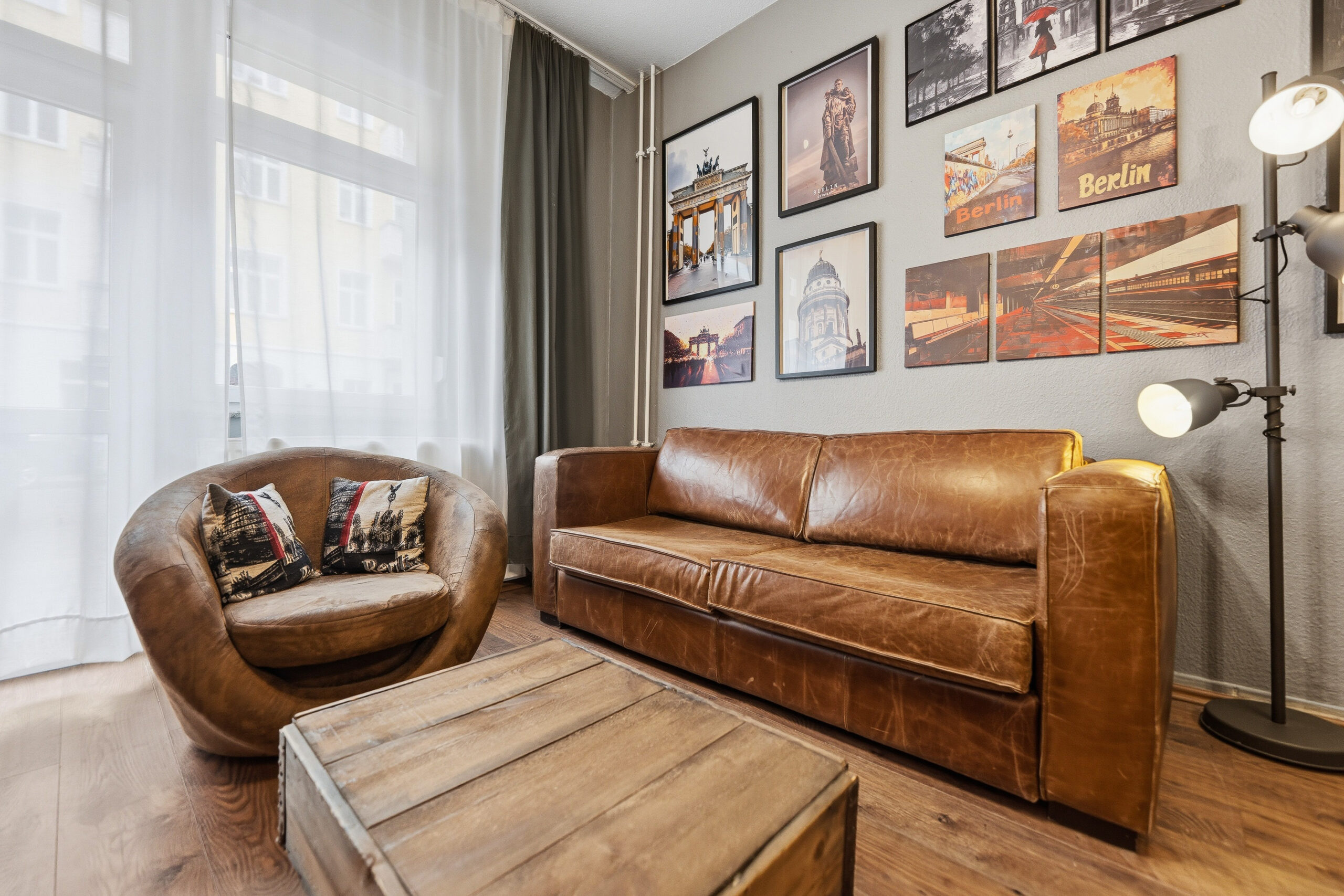 Leather sofa and armchair beneath gallery wall art