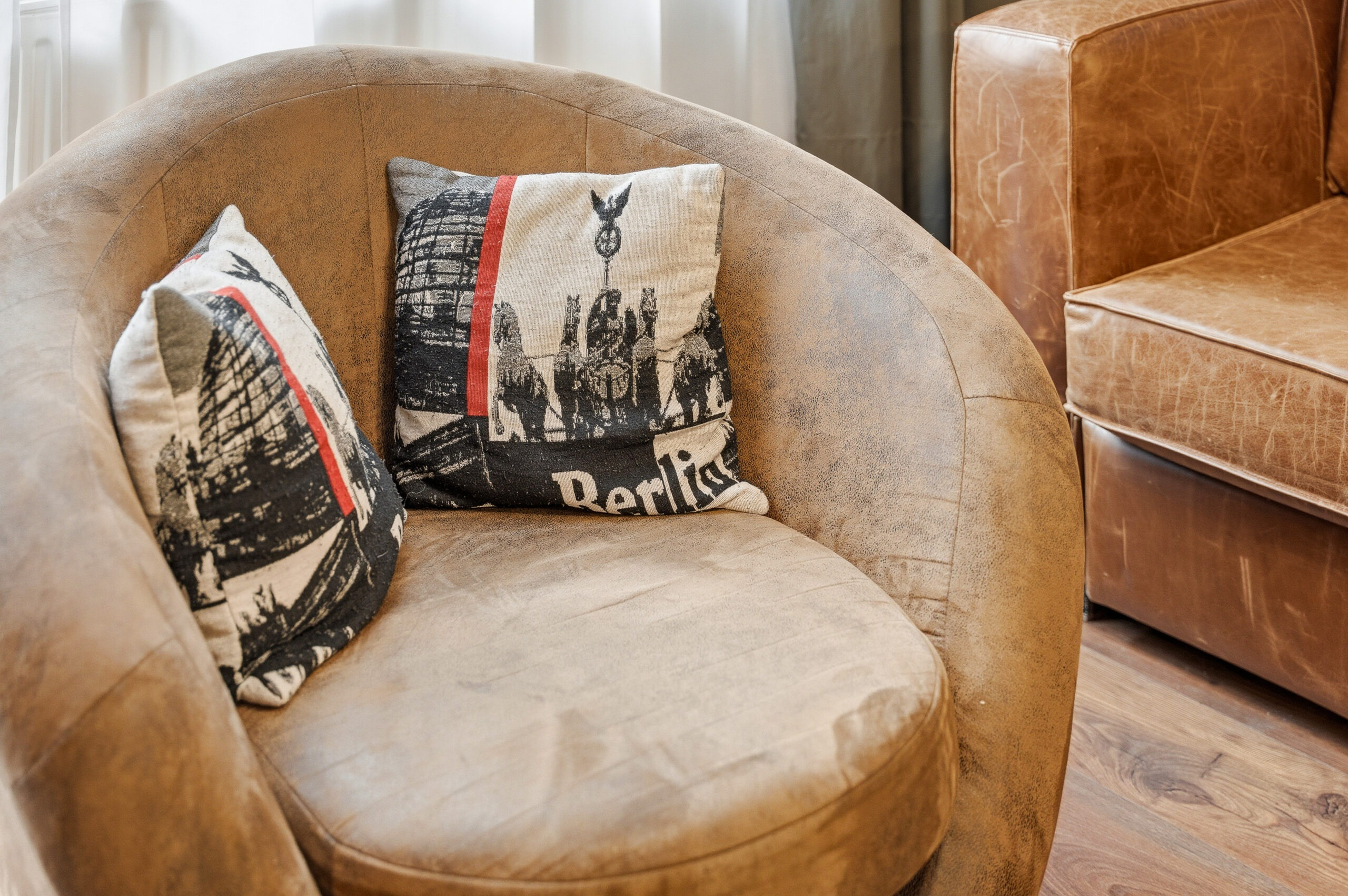 Leather armchair with Berlin-themed cushions