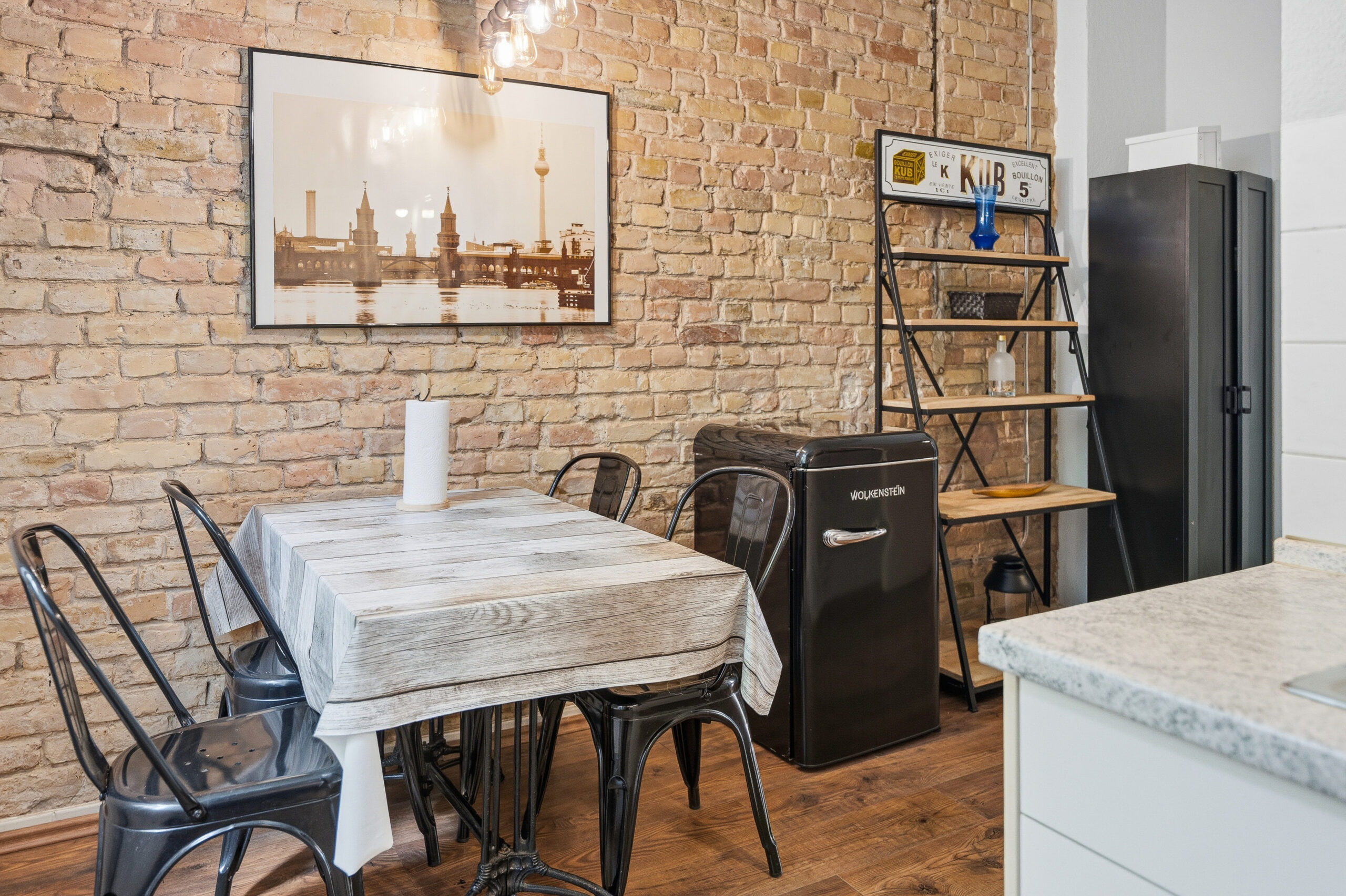 Dining table set against exposed brick wall
