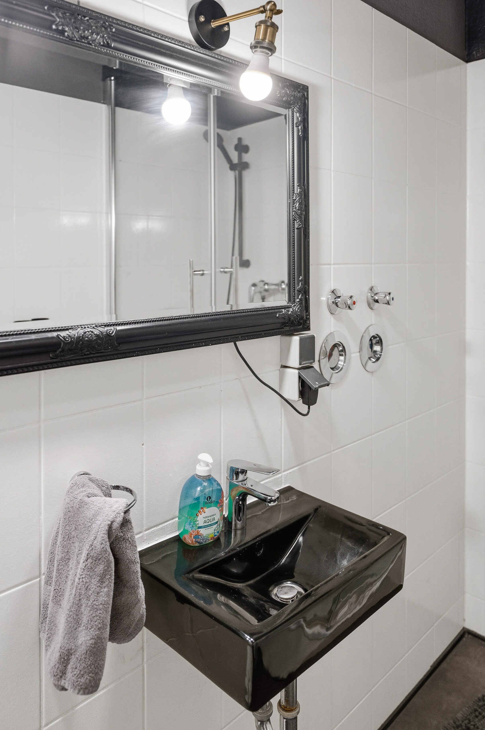 Black sink with mirror and shower fixtures