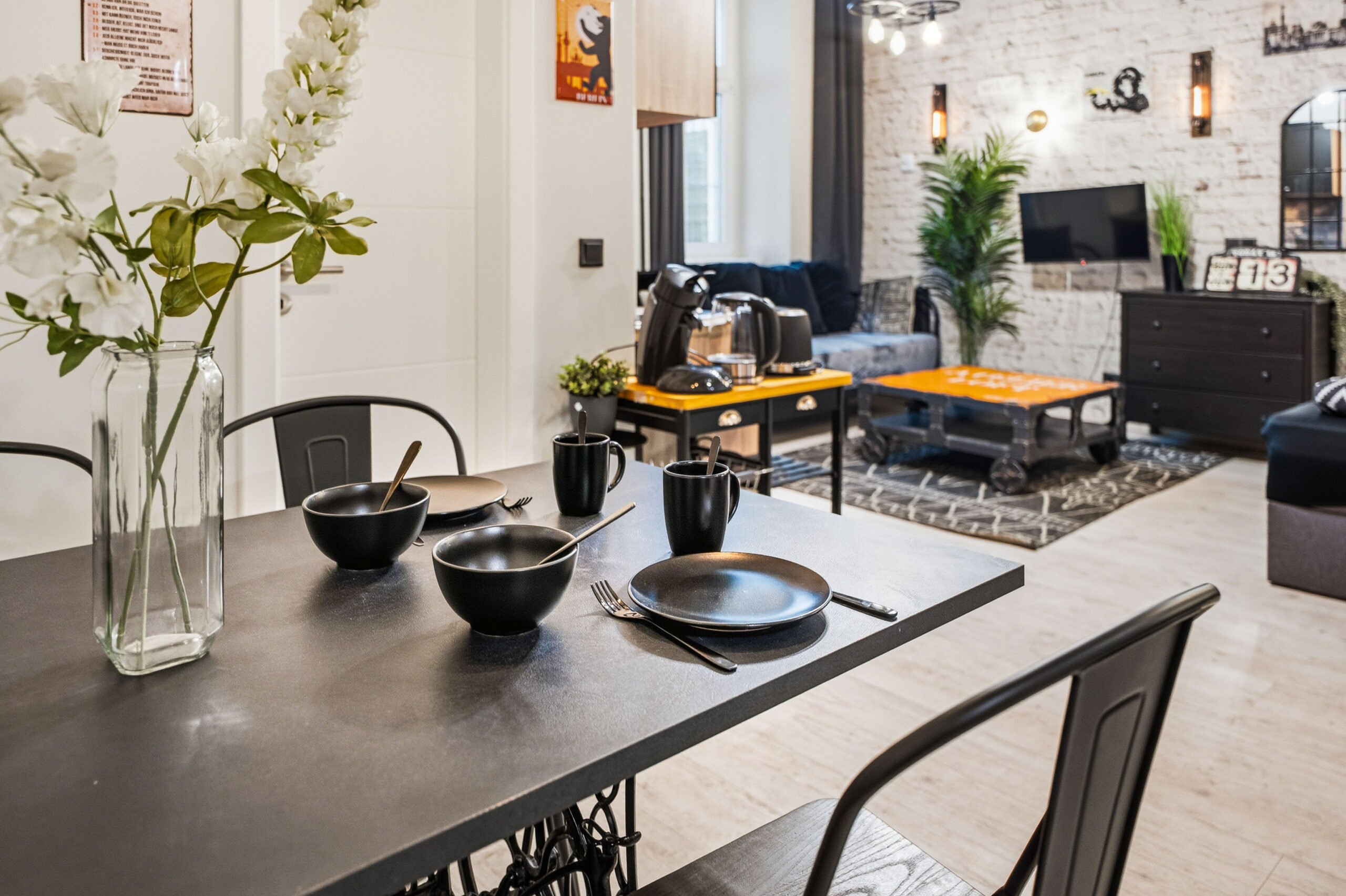 Dining table place setting with flowers and black chairs